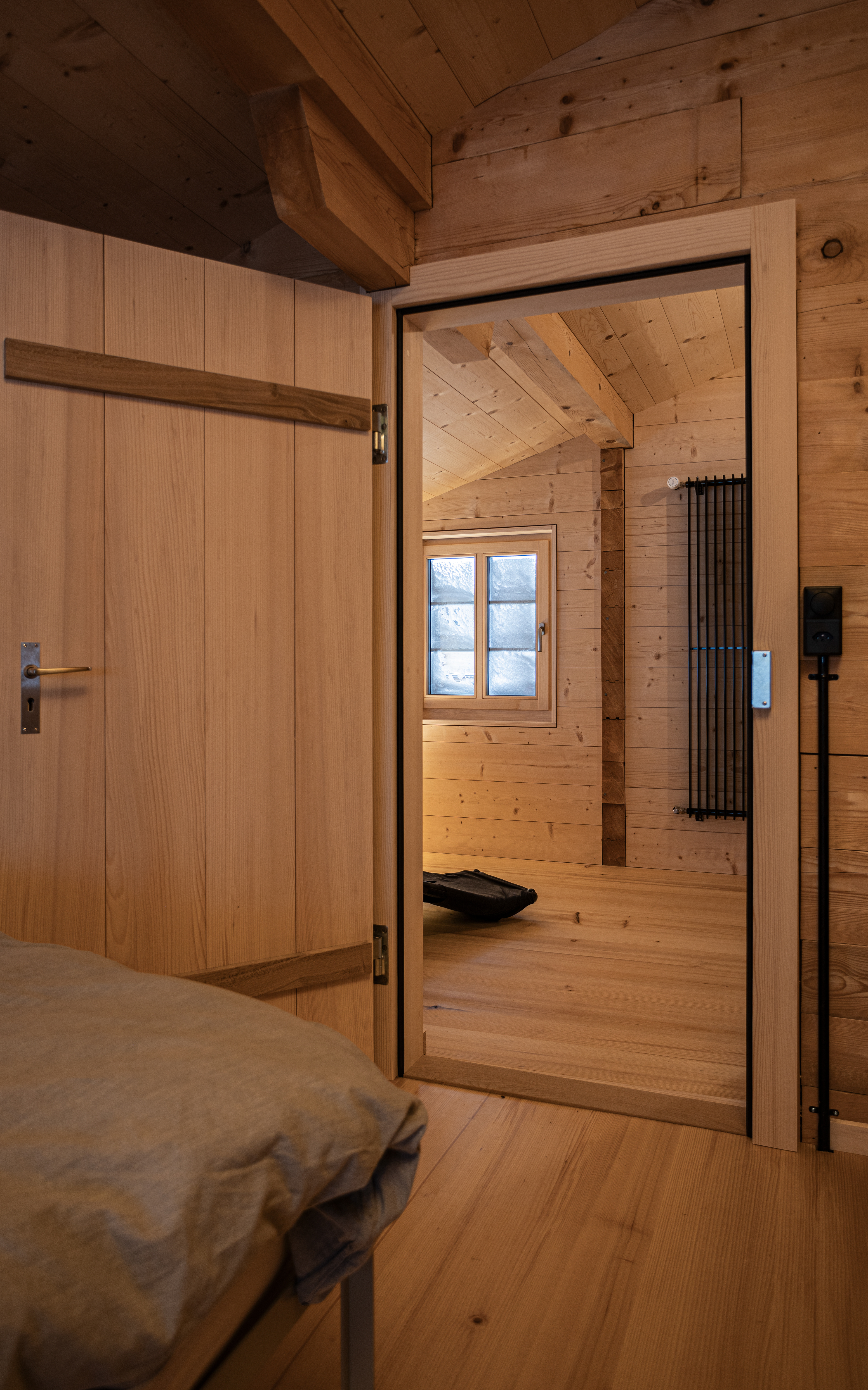 MKPHOTO, Architekturfotograf aus Aarau, Umgebautes Wohnhaus in Gadmen, Durchblick vom Schlafzimmer ins Wohnzimmer. 