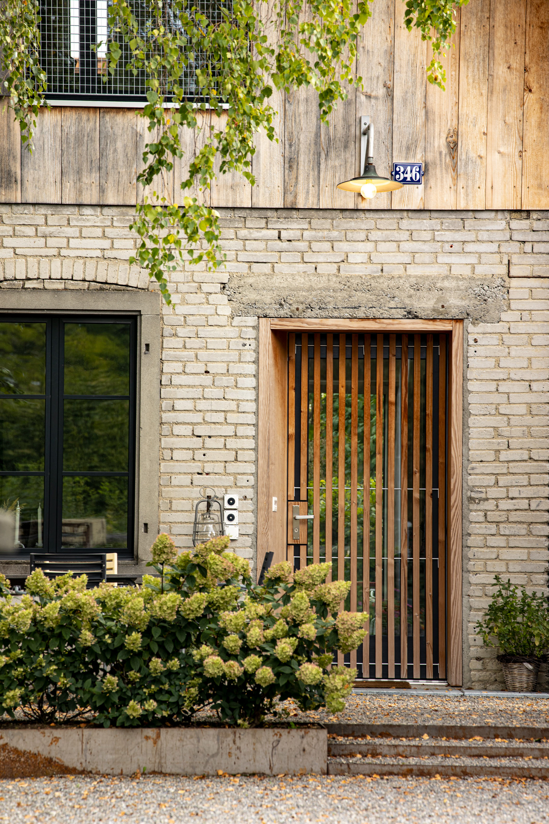 MKPHOTO, Architekturfotograf aus Aarau, Umgebaute Werkstatt in Gontenschwil, Hauseingang, Alter Backstein trifft auf neue Holzverschalung. 