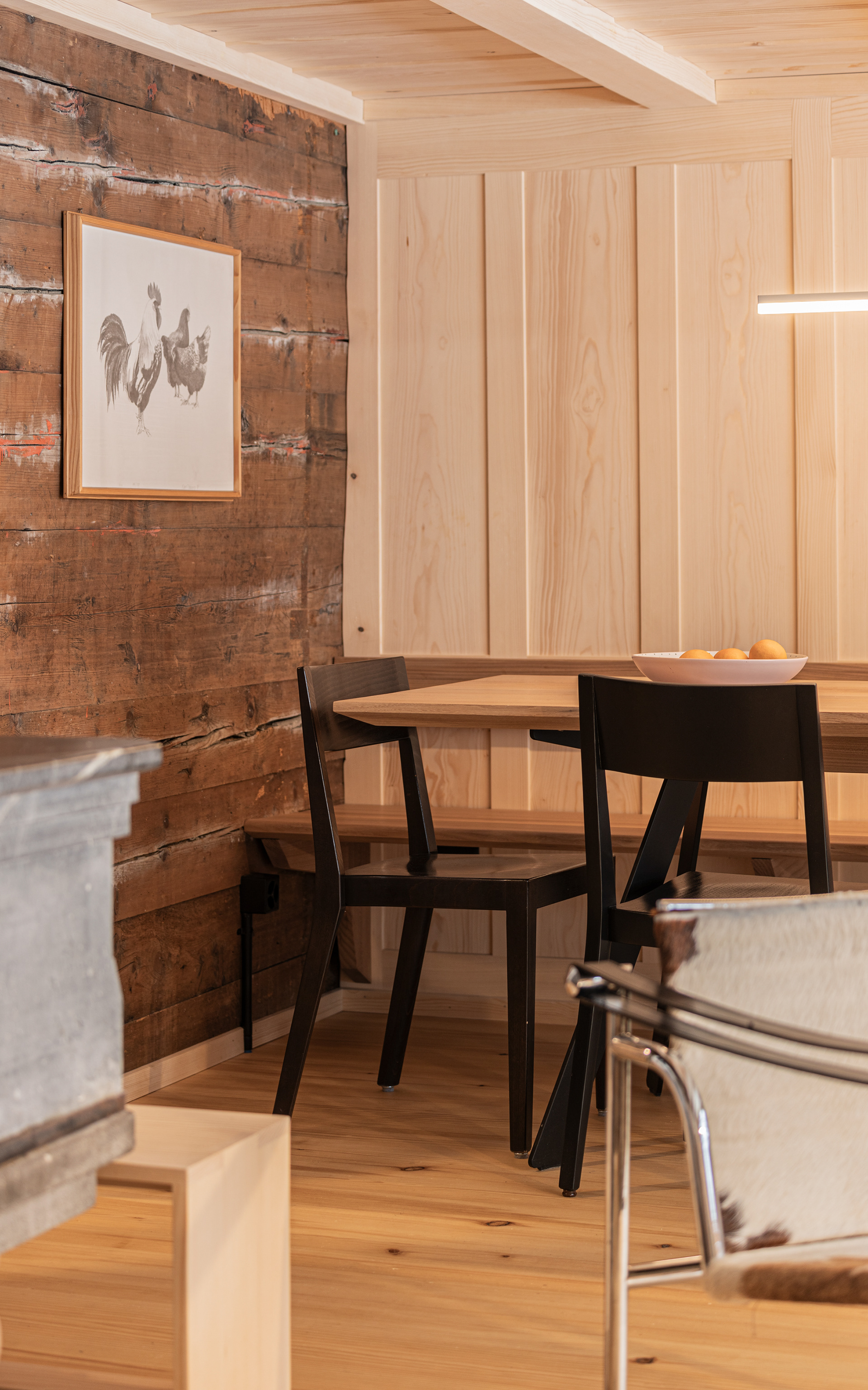 MKPHOTO, Architekturfotograf aus Aarau, Umgebautes Wohnhaus in Gadmen, Esszimmer mit alter Strickwand und neuer Massivholz Täferwand und Decke. 