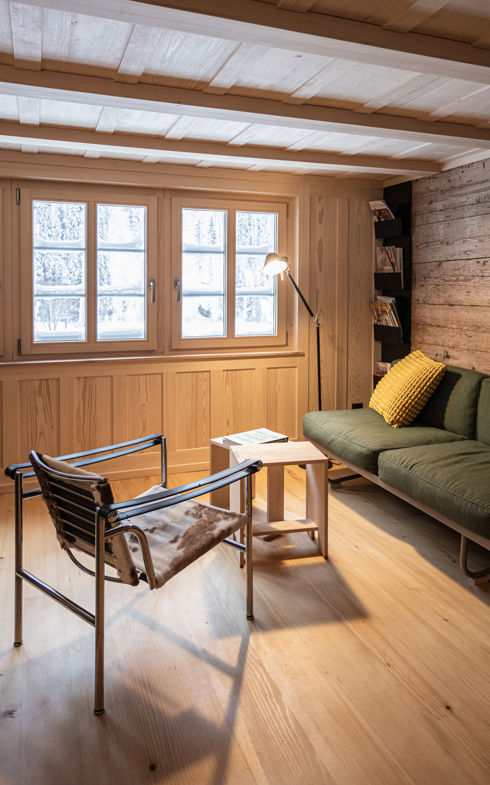 MKPHOTO, Architekturfotograf aus Aarau, Umgebautes Wohnhaus in Gadmen, Wohnzimmer mit gestemmter Holztäferwand und Designermöbel. 