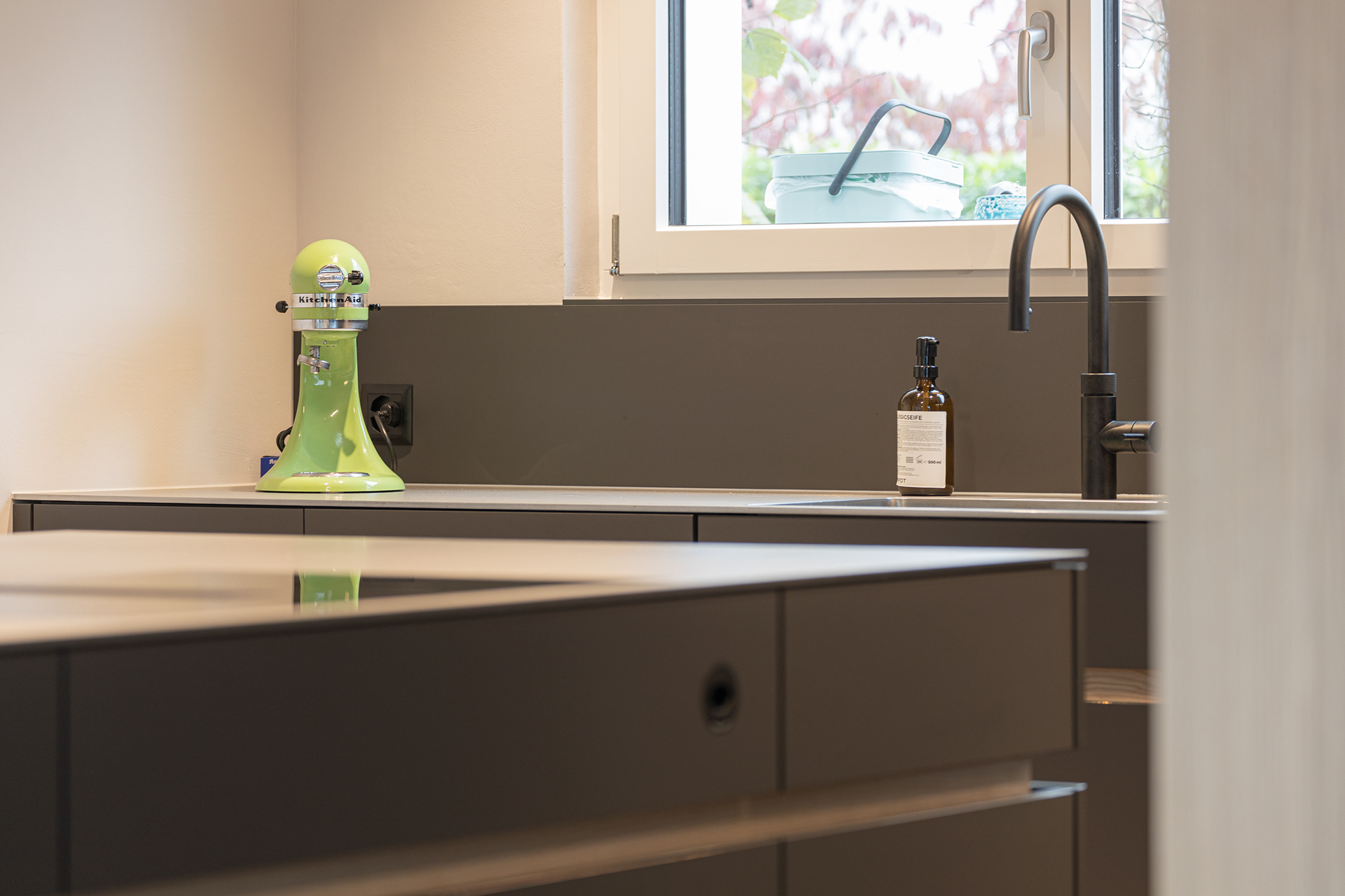 MKPHOTO, Architekturfotograf Zürich, Umbau Küche Oberrohrdorf, Schwarze Küche mit Chromstahlabdeckung und Eschenholz. 