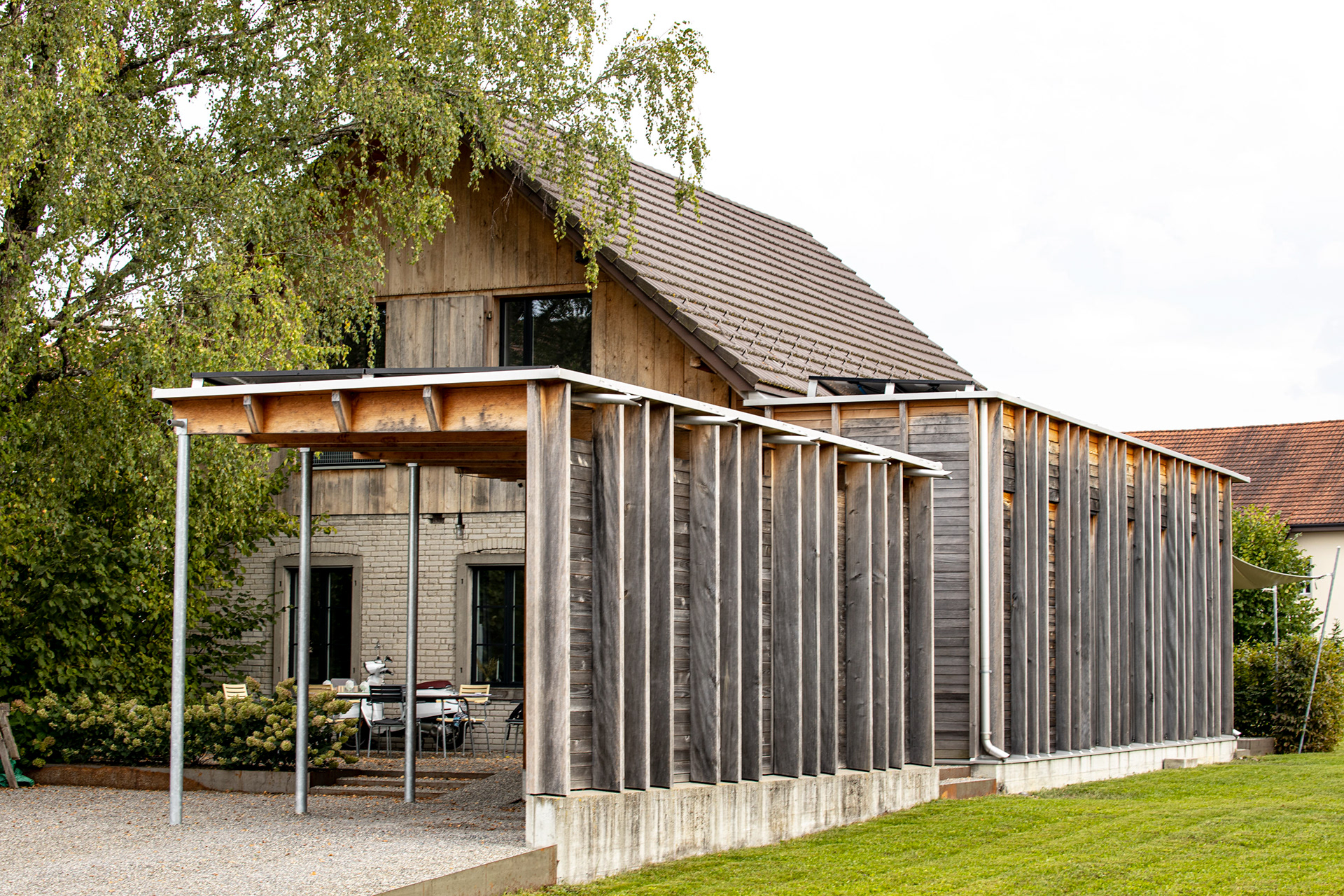 MKPHOTO, Architekturfotograf aus Aarau, Umgebaute Werkstatt in Gontenschwil, Ostfassade mit Auto Unterstand und Sitzplatz im Eingangsbereich. 