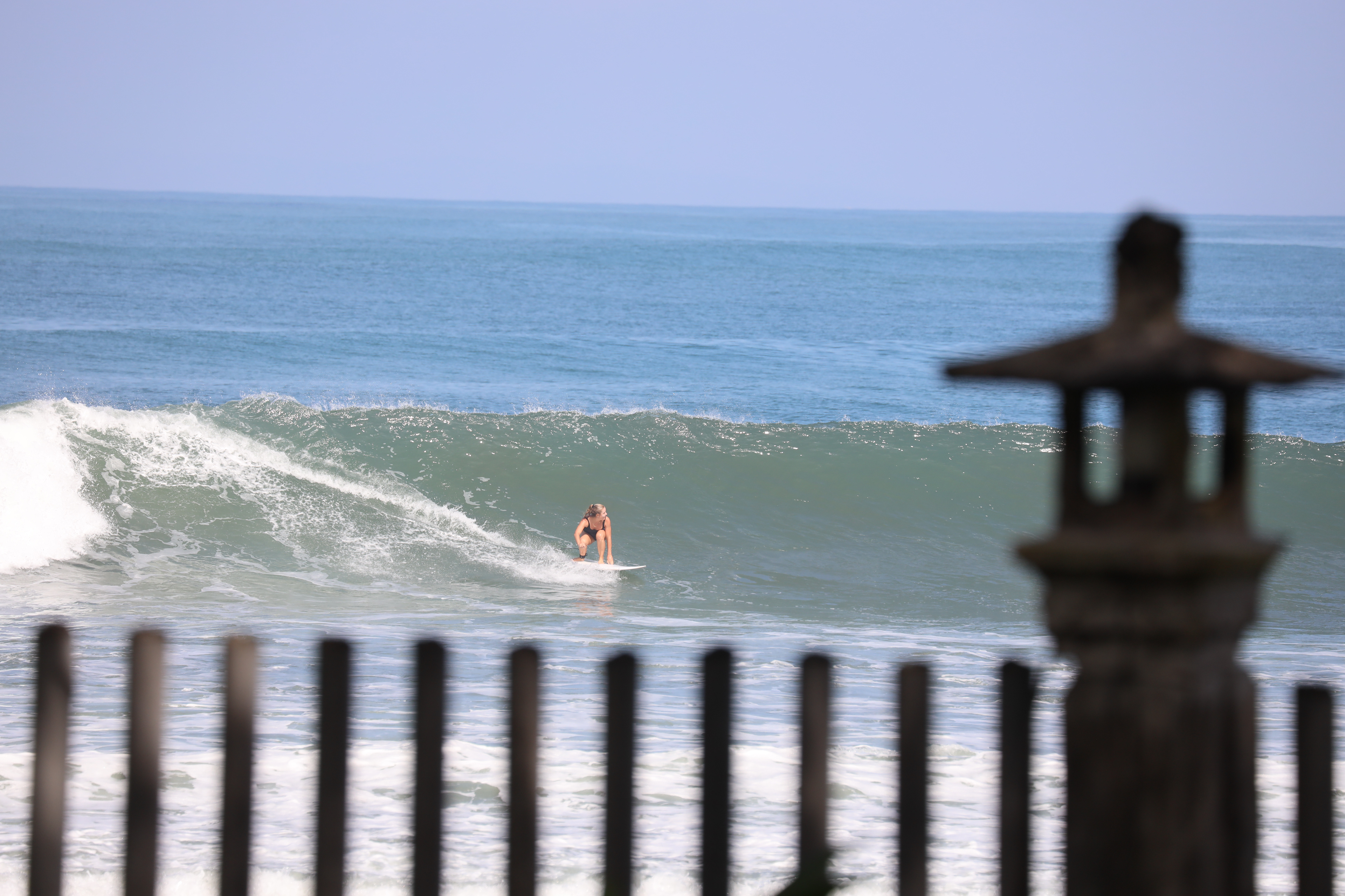 MKPHOTO, Landschaftsfotograf Schweiz, Frau surft eine Welle in Bali, Indonesien. 