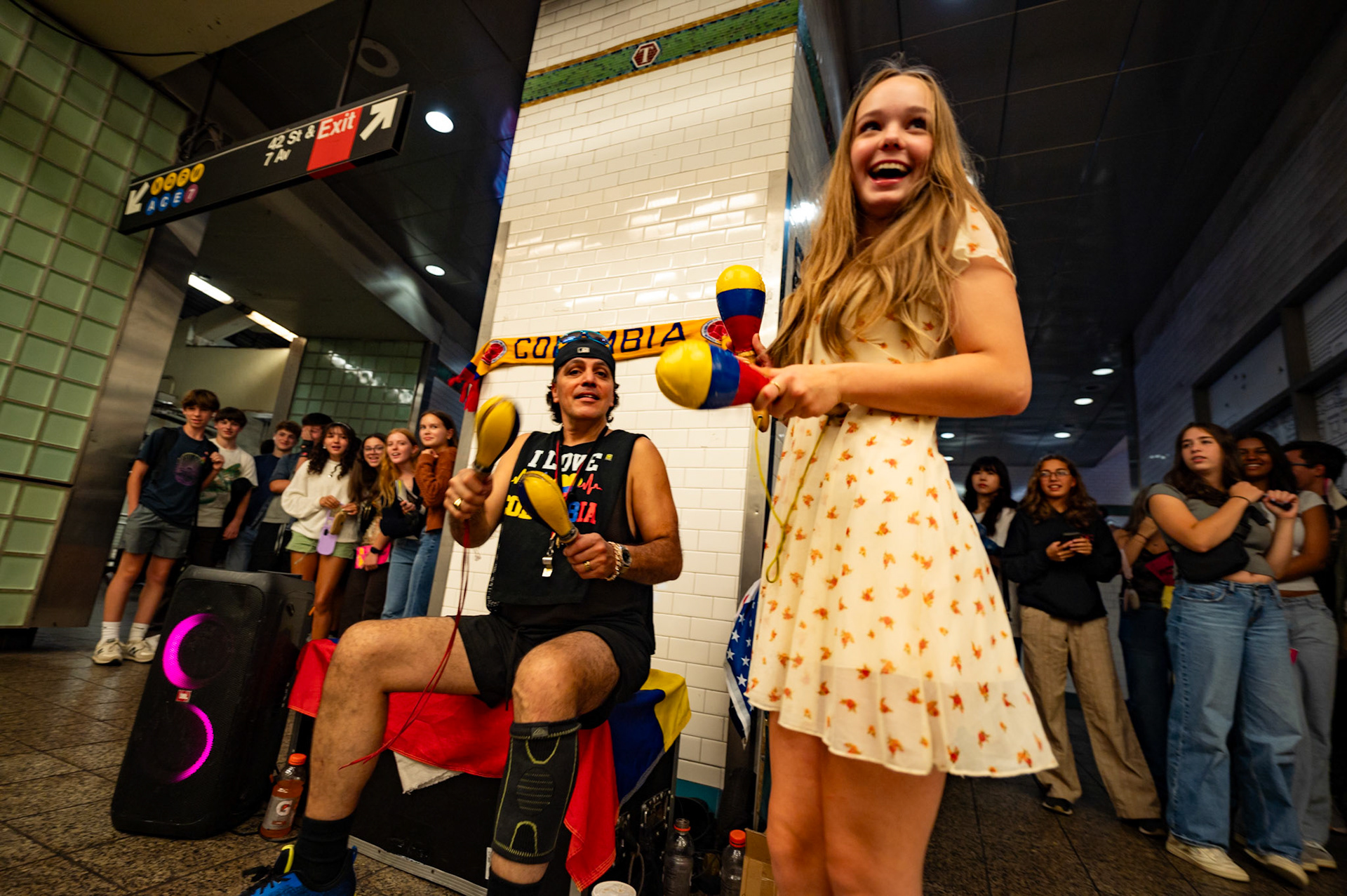Molly Loyd '27 shakes maracas alongside a street performer in the Times Square-42nd Street subway station on Oct. 5, 2024. The choir used the New York City subway system to travel throughout Manhattan, including their trips from Broadway back to the Cathedral.