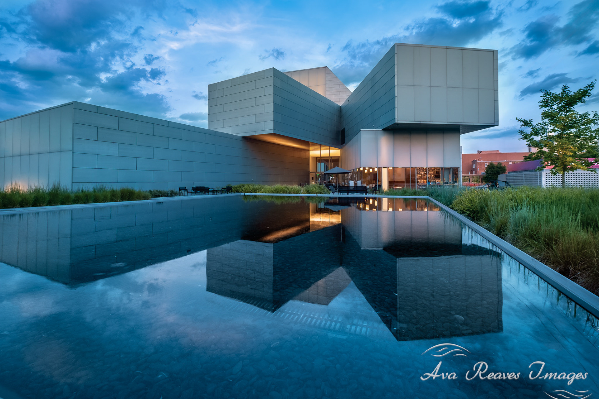 A low-angle view of the modern, geometric ICA building in Richmond, perfectly reflected in a still pool under a twilight sky.
