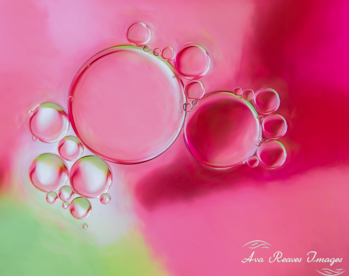 An abstract of oil and water that created pink and green bubbles