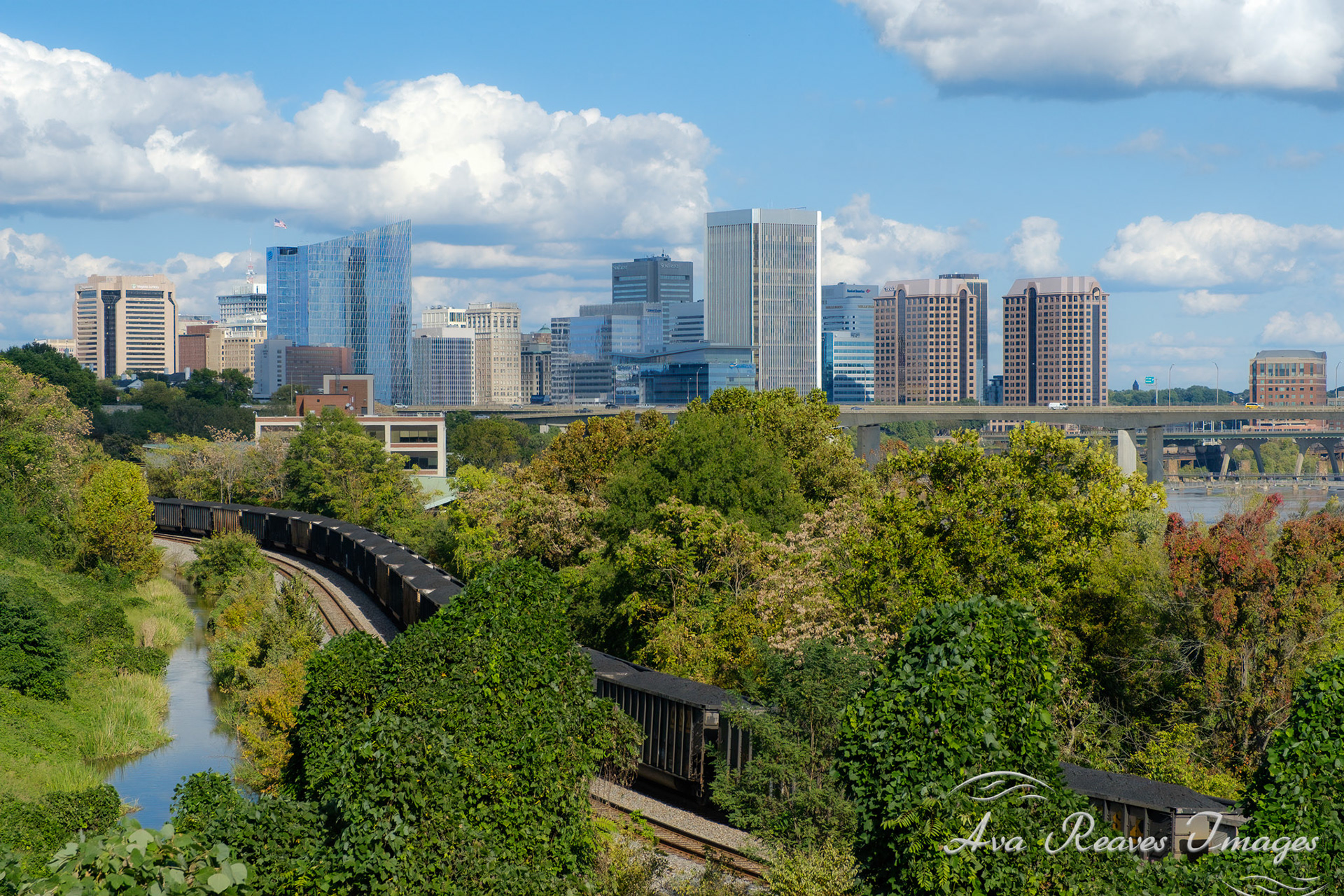 The CSX coal train follows the north bank trail and kanawha canal with the city of richmond virginia in the background