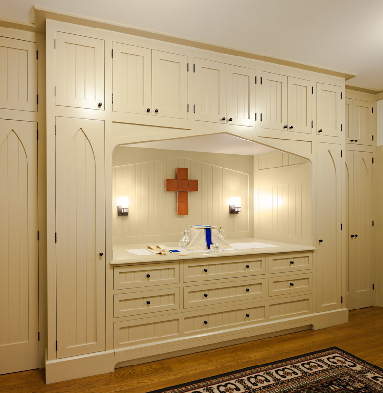 Sacristy with gothic arch painted wood storage cabinets.