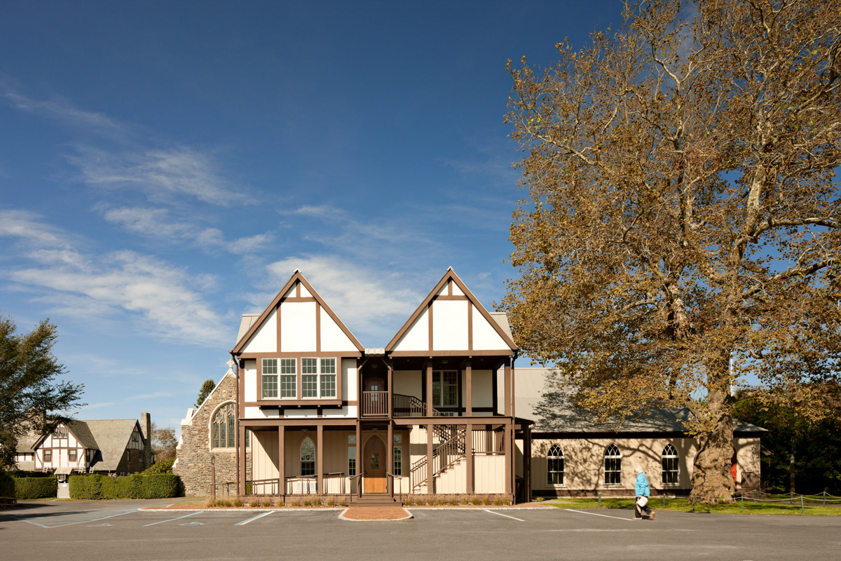 Parish Hall exterior with double half-timbered gables and gothic arched windows and doors.