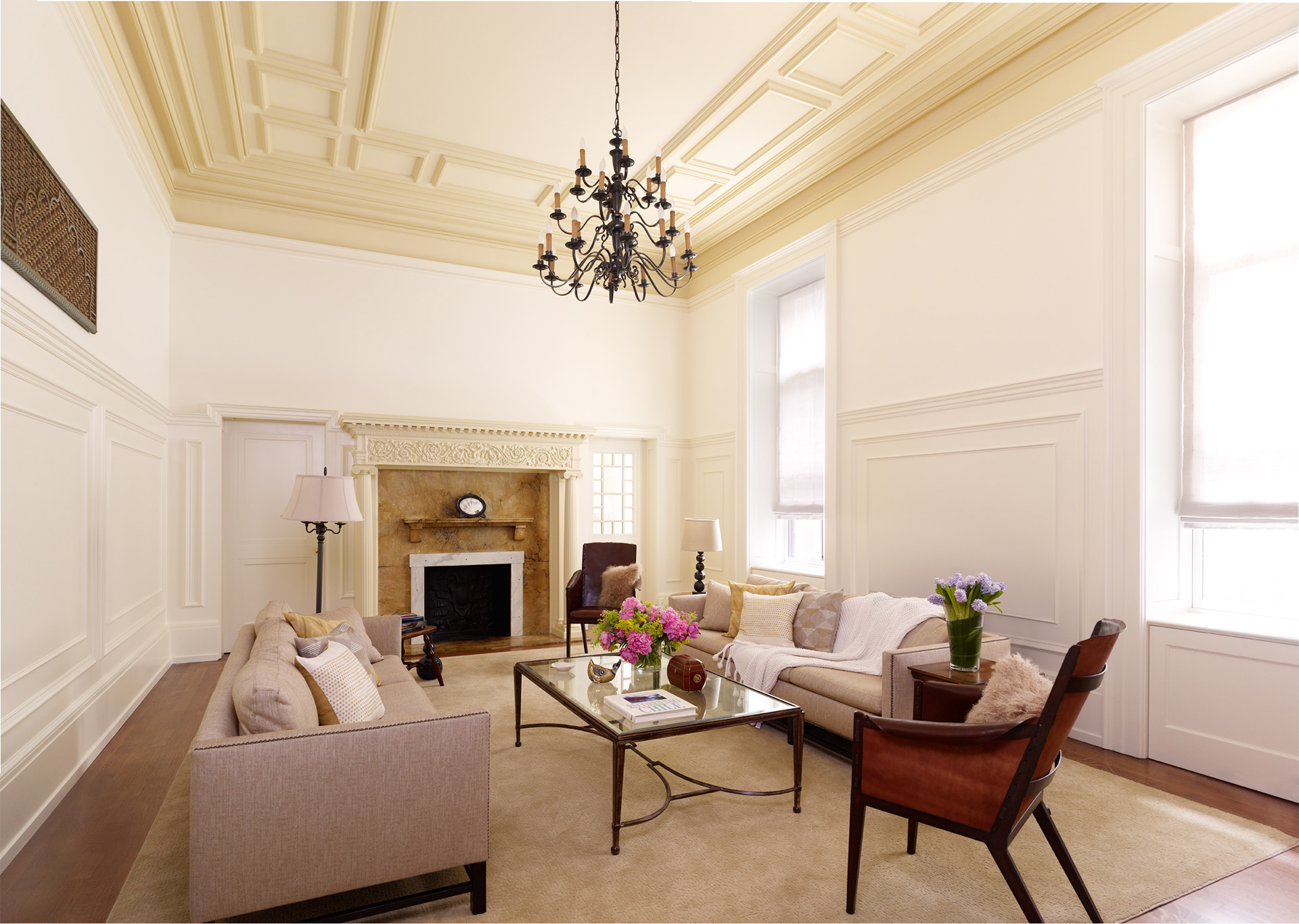 Townhouse restored paneled living room with paneled ceiling and a fireplace with ionic columns.