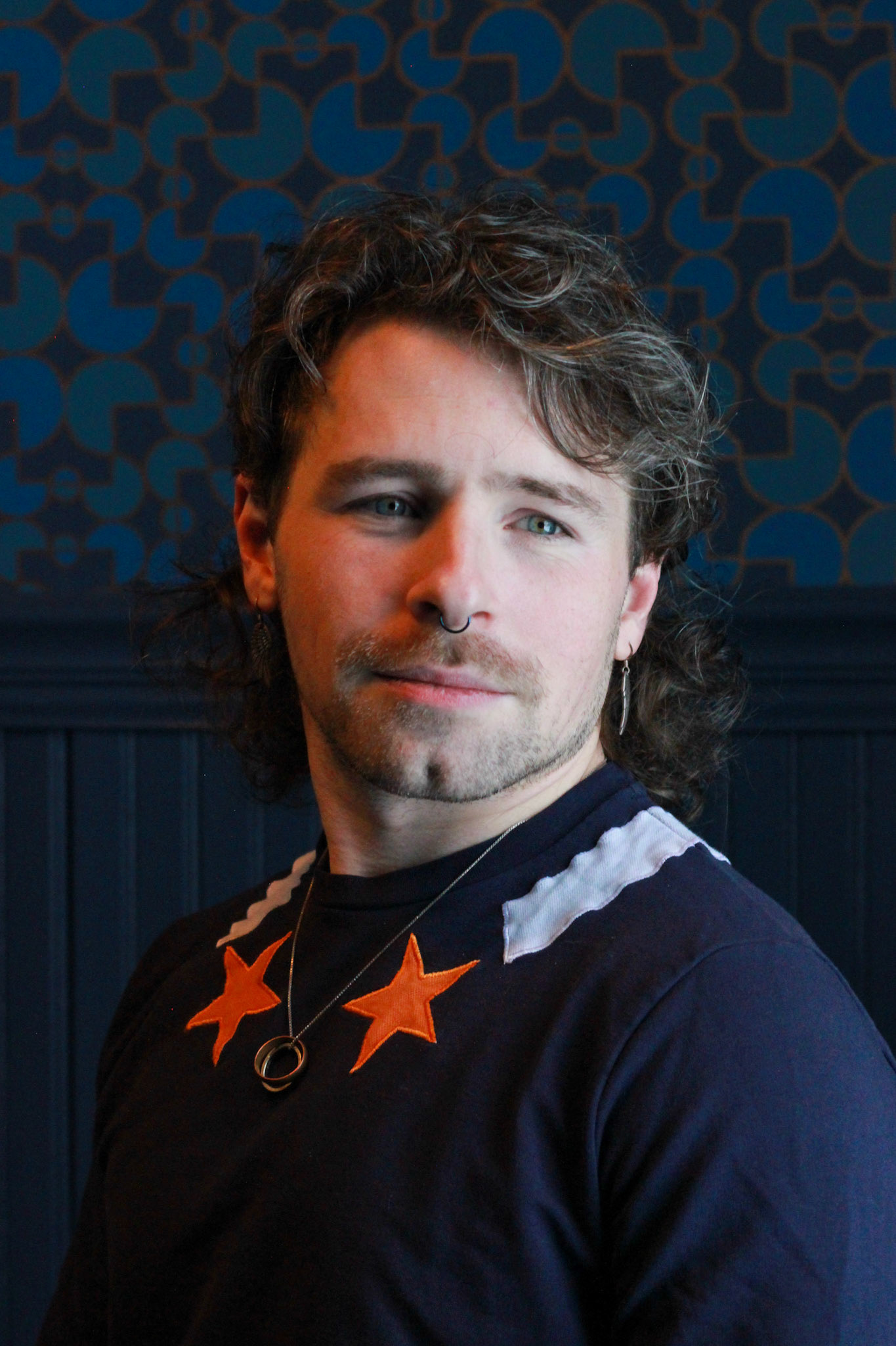 Jake Krueger, They/Them, is a queer chaplain, innkeeper, community organizer, and death educator. Through much of their life Jake has been concerned with questions related to spirituality, connection, and meaning-making both as an individual seeker, and as a matter of discourse and practice within the queer community. They see building queer spiritual communities as the center of their work in the world–lifting up queerness and queer people as beautiful and sacred. When they’re not in chaplain mode you can often find them at Mercury Inn, a small bed and breakfast in Portland that they co-own, co-habitate, and co-operate with one of their partners.  Jake is a big fan of all things science fiction and fantasy, spurned by a deep and abiding childhood love of the X-Men, their favorite story-world metaphor for the queer experience. X-Men taught Jake about the importance of cultivating a sense of self worth and building a chosen family in a world that tries to tear queer people down for our queerness. The lessons learned in reading those silly superhero comics formed the foundation for the community building efforts Jake pursues now.  If you’d like to see the kind of community Jake is trying to build check out the monthly LGBTQ+ Heart Circle hosted at Portland’s Equality Community Center–you can find information on the next circle on the ECC’s calendar, or follow Jake at @theheartfarmer for story announcements and updates.