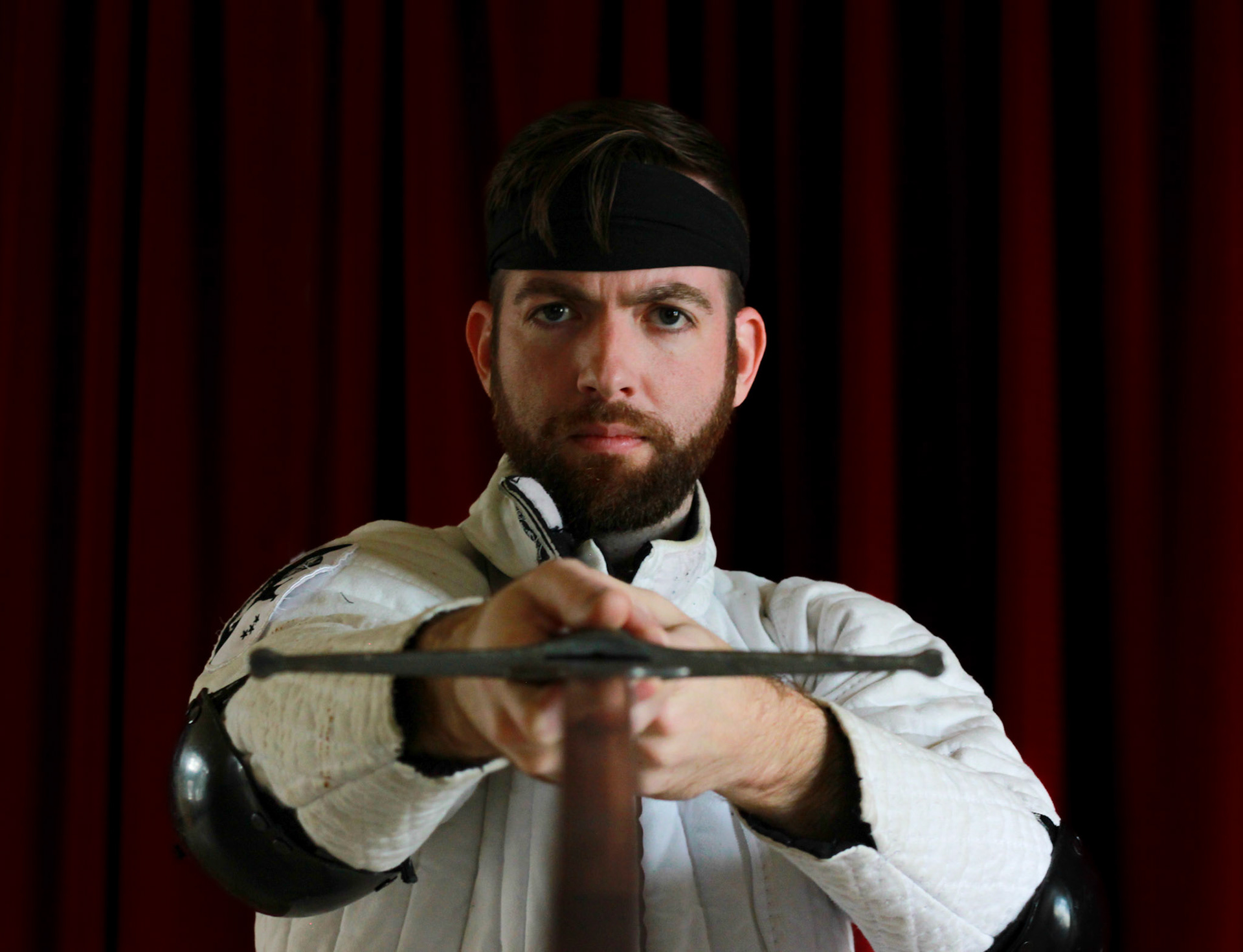 Kasey, He/Him . “I discovered longsword fencing because I wanted to fight with swords, but I fell in love with it and Historical European Martial Arts (HEMA) for the community and friendships I made. My first instructors and club embraced that I was gay, which was welcome to me in a world where other sports had for many years seemed foreign and out of reach. It's a huge honor to start and run a HEMA club here in Maine. When I'm fighting or sparring-- I feel so full, alive, and honestly... I just have a lot of fun doing it. I want Moose Historical Fencing to be a space where everyone can have that, and where anyone can train safely and grow as fighters and as people."