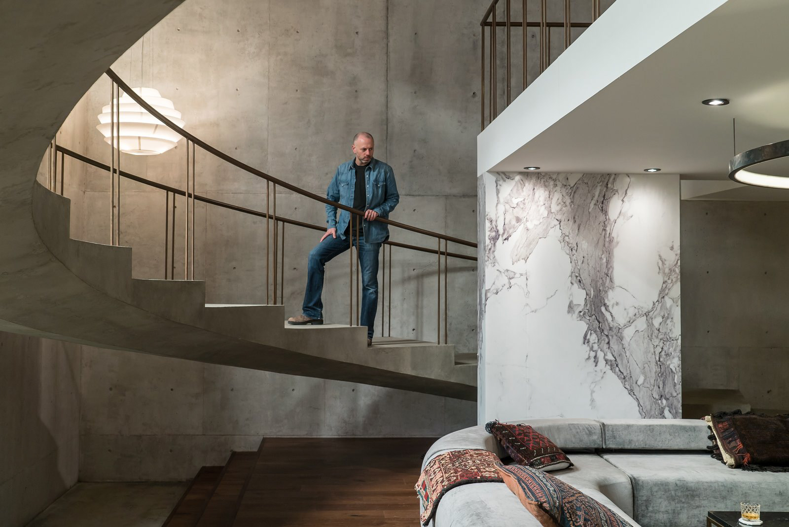 Concrete walls and floors were created by pouring a quarter-inch layer of concrete over plywood. While marble is traditionally painted for film and television sets, Novotny took a different route to save time. After hunting down the perfect slab of Calacatta marble in a showroom, he hired a photographer to capture a high-resolution image that was then printed on sheets of white plastic by Astek Wallcovering in Los Angeles.