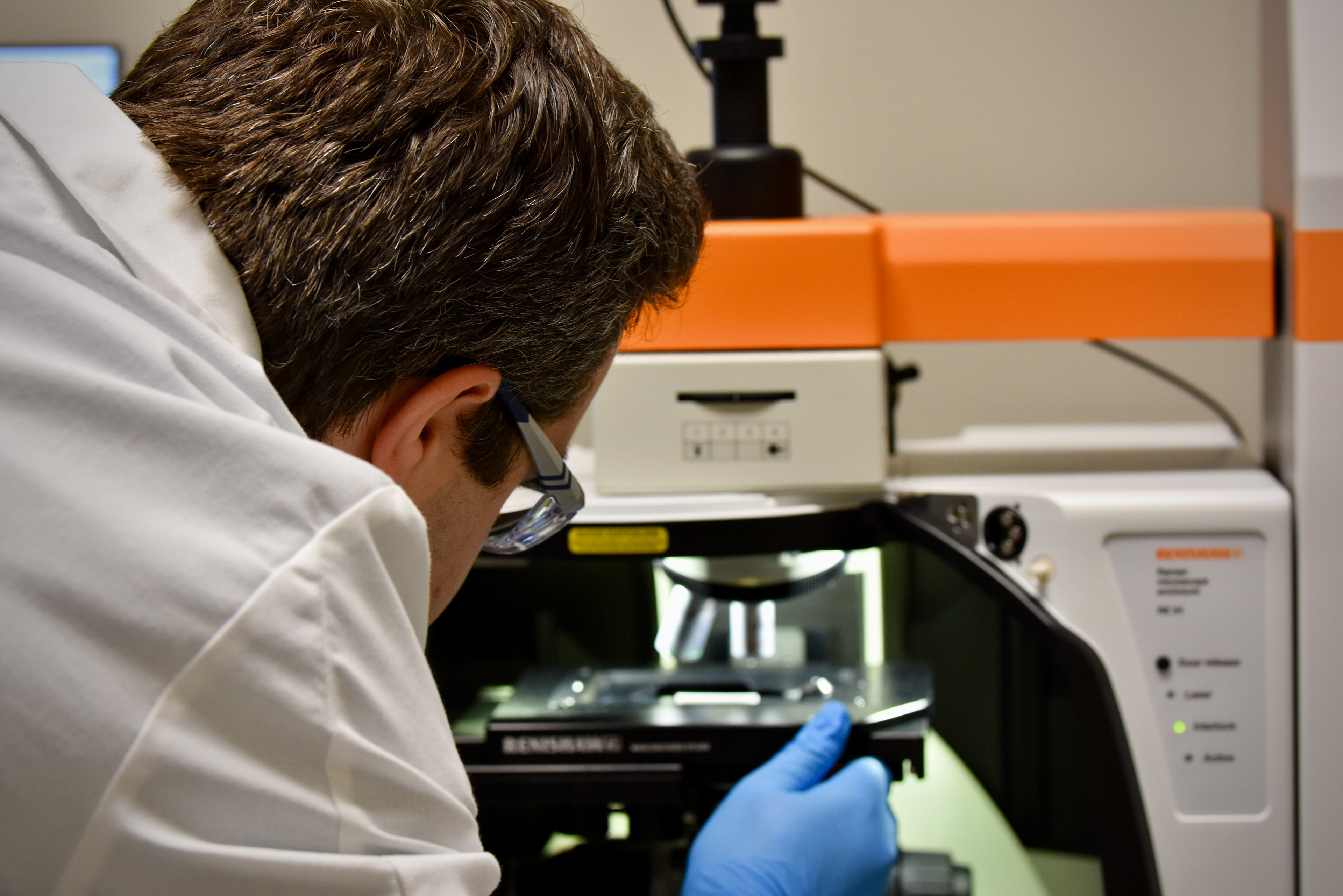 Scientist adjusting a microscope system