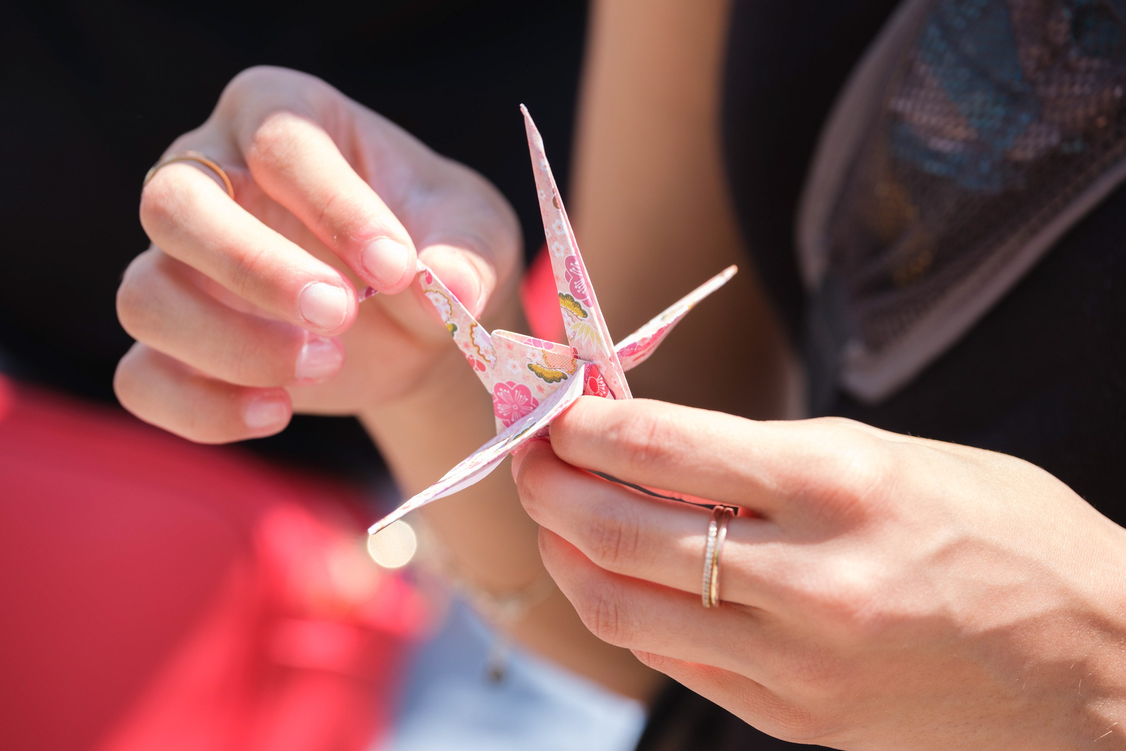 Hands folding a paper crane