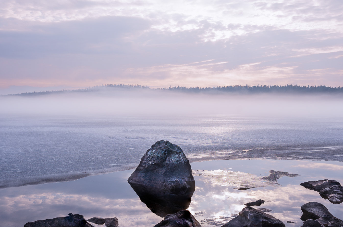 Sweden surreal winter landscape featuring mist over a frozen lake