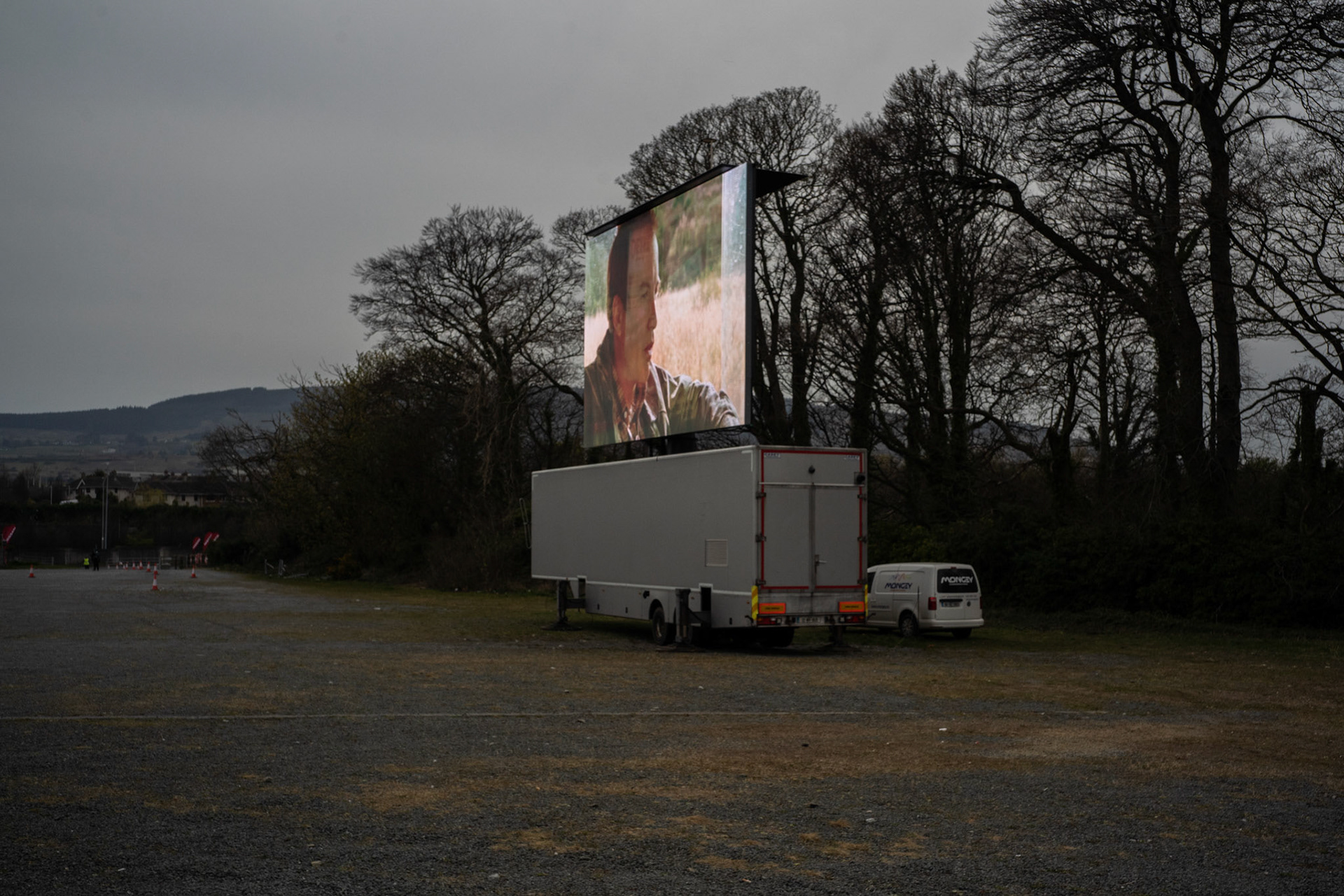 At the edge of an expansive parking lot serving Leopardstown Racecourse, a horse-racing venue in south Dublin, a 50 m square screen stands high ahead of another drive-in theatre session. Dublin, Ireland - March 23, 2020.