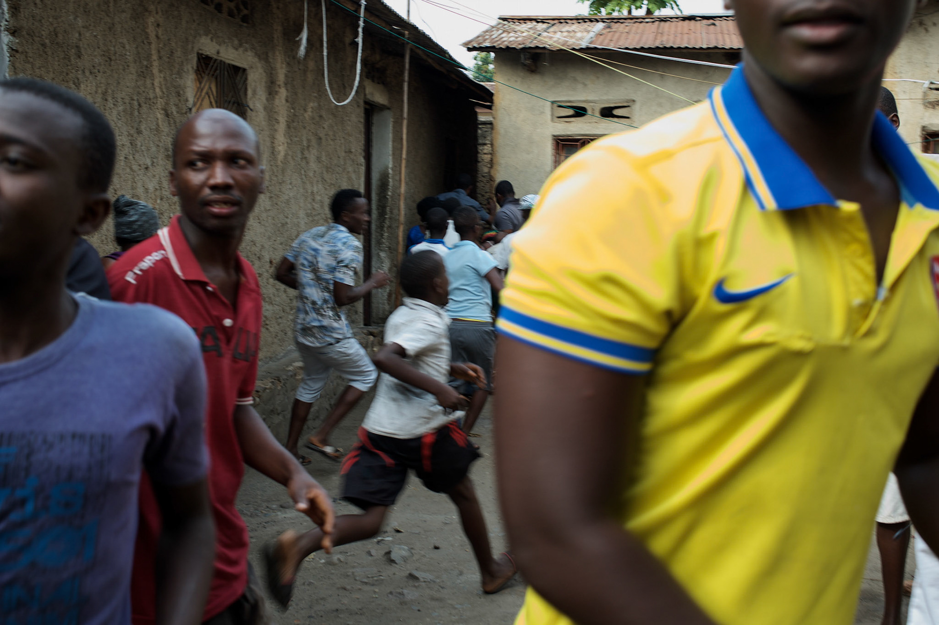Locals react to gunfire shot by the Burundian National Police officers during a raid in Cibitoke neighbourhood, Bujumbura.