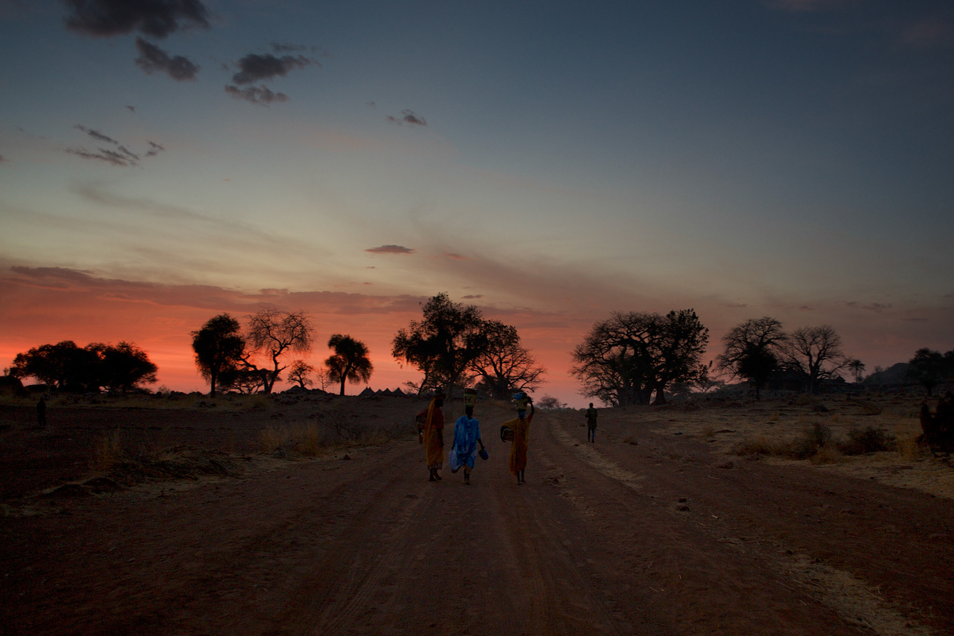 Local women walk along a road near the Nuba village of Tess in South Kordofan.