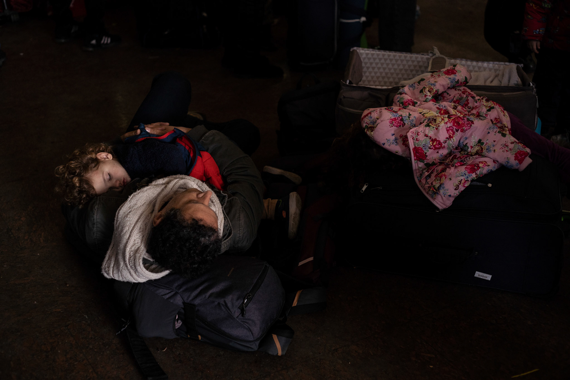 A internal displaced father and son take a rest on the floor of Lviv main train station, as they await the opportunity to flee towards the Polish border.