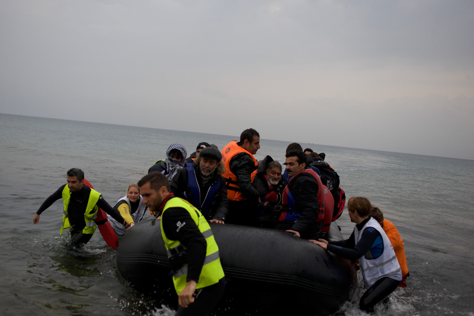 Volunteers help a group of about 60 migrants land at a beach outside Mytilene in Lesbos island, Greece.