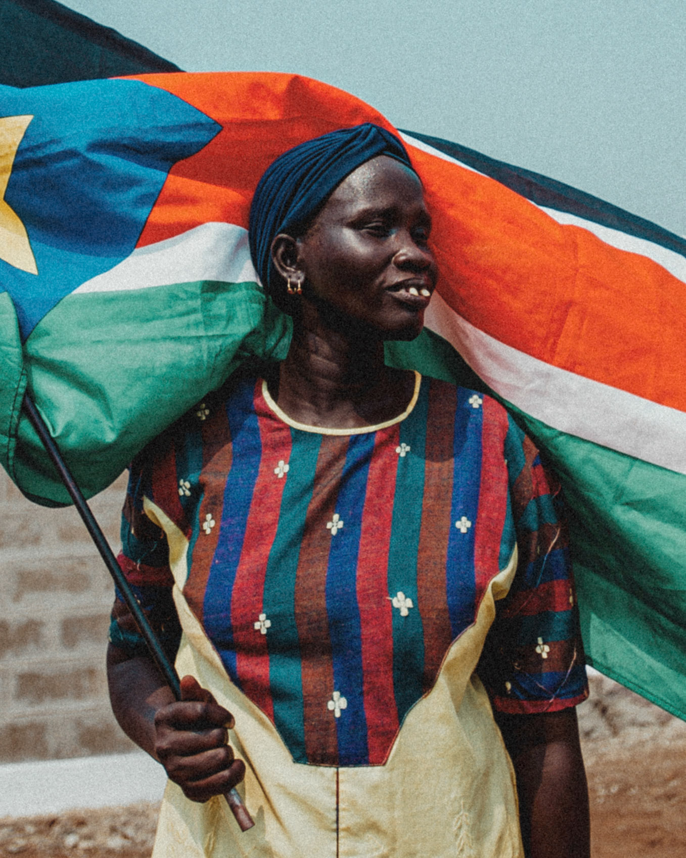 A South Sudanese woman poses with the national flag during a mock parade in preparation for independence day in central Juba.