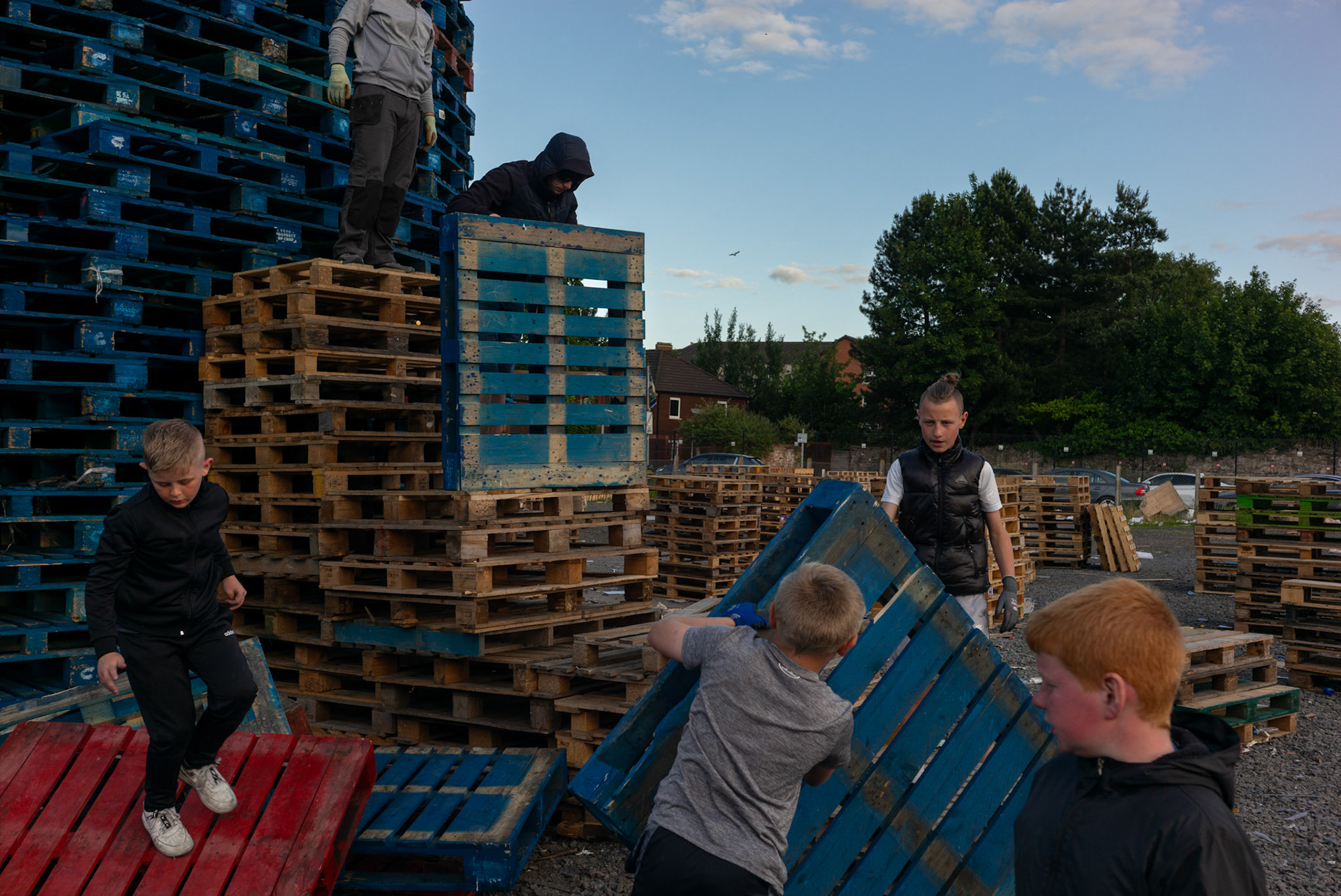 Local children and young men from Donegall Pass, a predominantly working-class loyalist community in inner-city Belfast, during the building of the large wooden pallet bonfire to be set alight for the Twelfth of July celebrations in Belfast, Northern Ireland, on June 26, 2021.