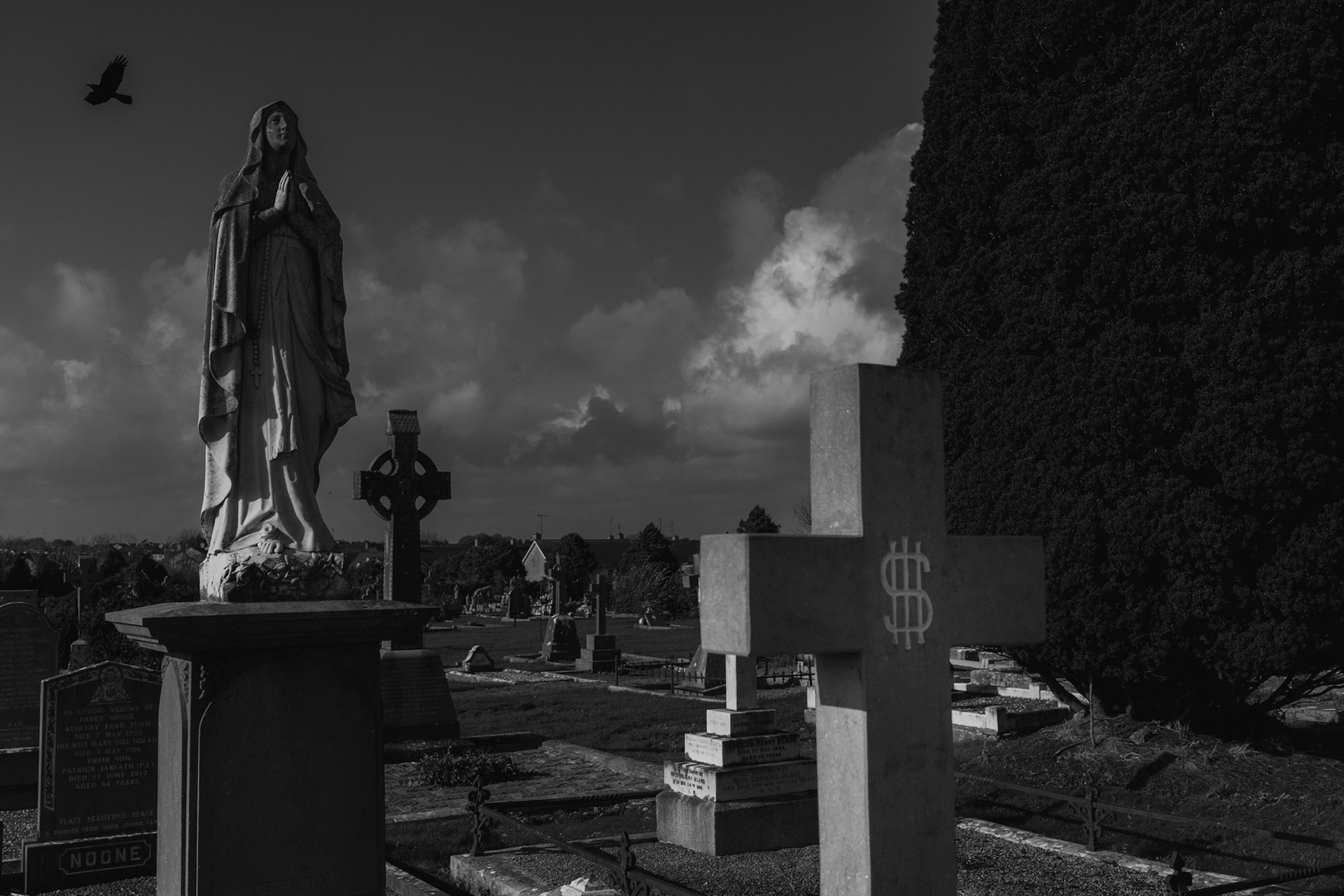 TUAM, IRELAND - OCTOBER 26, 2022: View of some of the headstones and statues at the cemetery in Tuam, Ireland, on October 26, 2022. In 2014, local historian, Catherine Corless, went public with information concerning the deaths of 798 children at St. Mary’s Mother and Baby Home, a maternity home for unmarried mothers and their children run by the Bon Secours order, located a few hundred meters from the town’s cemetery. Corless' research led her to conclude that almost all had been buried in an unmarked and unregistered site at the Home. Subsequent excavations carried out by an Irish government appointed Commission, found a significant quantity of human remains in a vault with twenty chambers, believed to be part of an old septic tank from the period the site was use as a workhouse. CREDIT: Paulo Nunes dos Santos for The New York Times