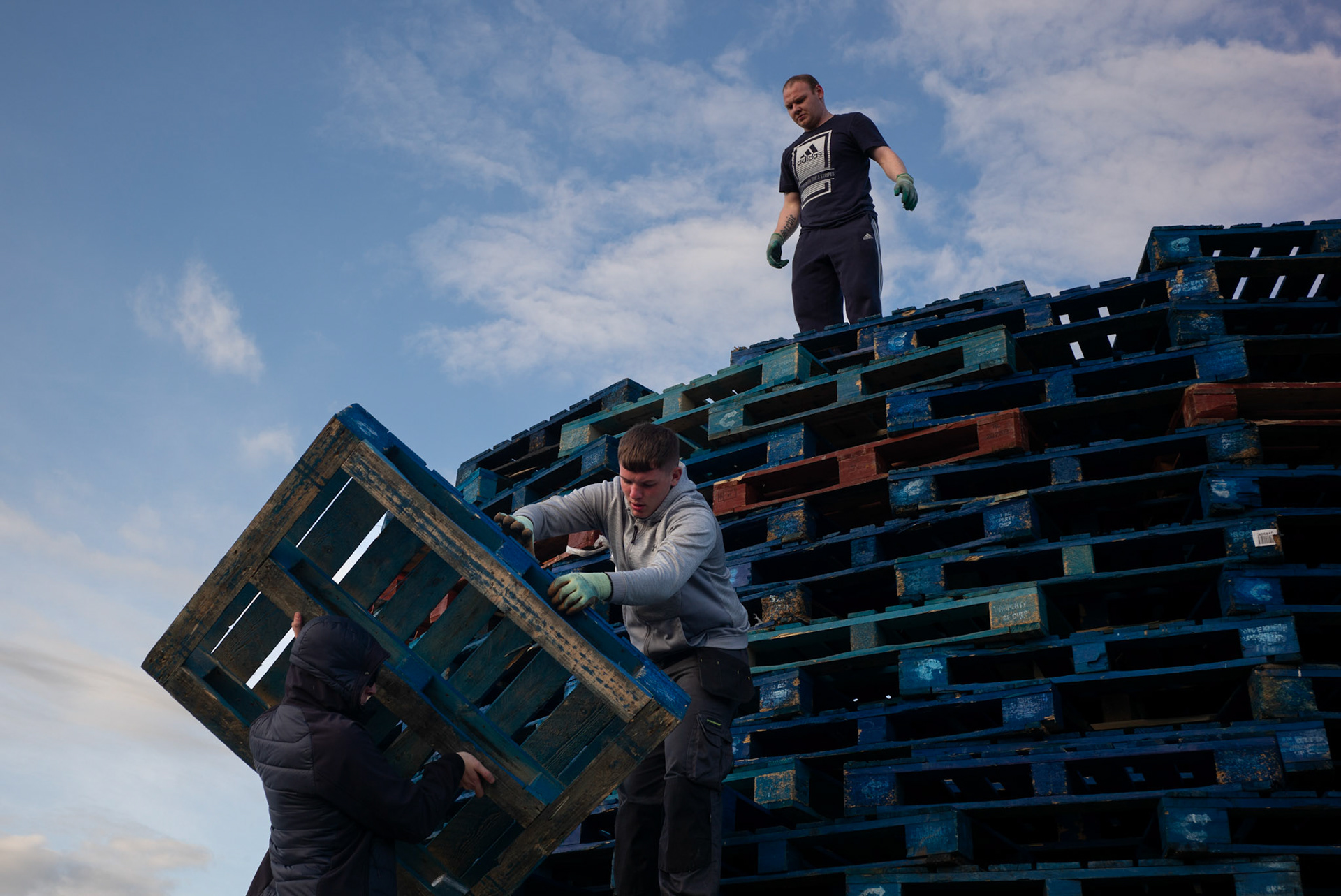 Local children and young men from Donegall Pass, a predominantly working-class loyalist community in inner-city Belfast, during the building of the large wooden pallet bonfire to be set alight for the Twelfth of July celebrations in Belfast, Northern Ireland, on June 26, 2021.