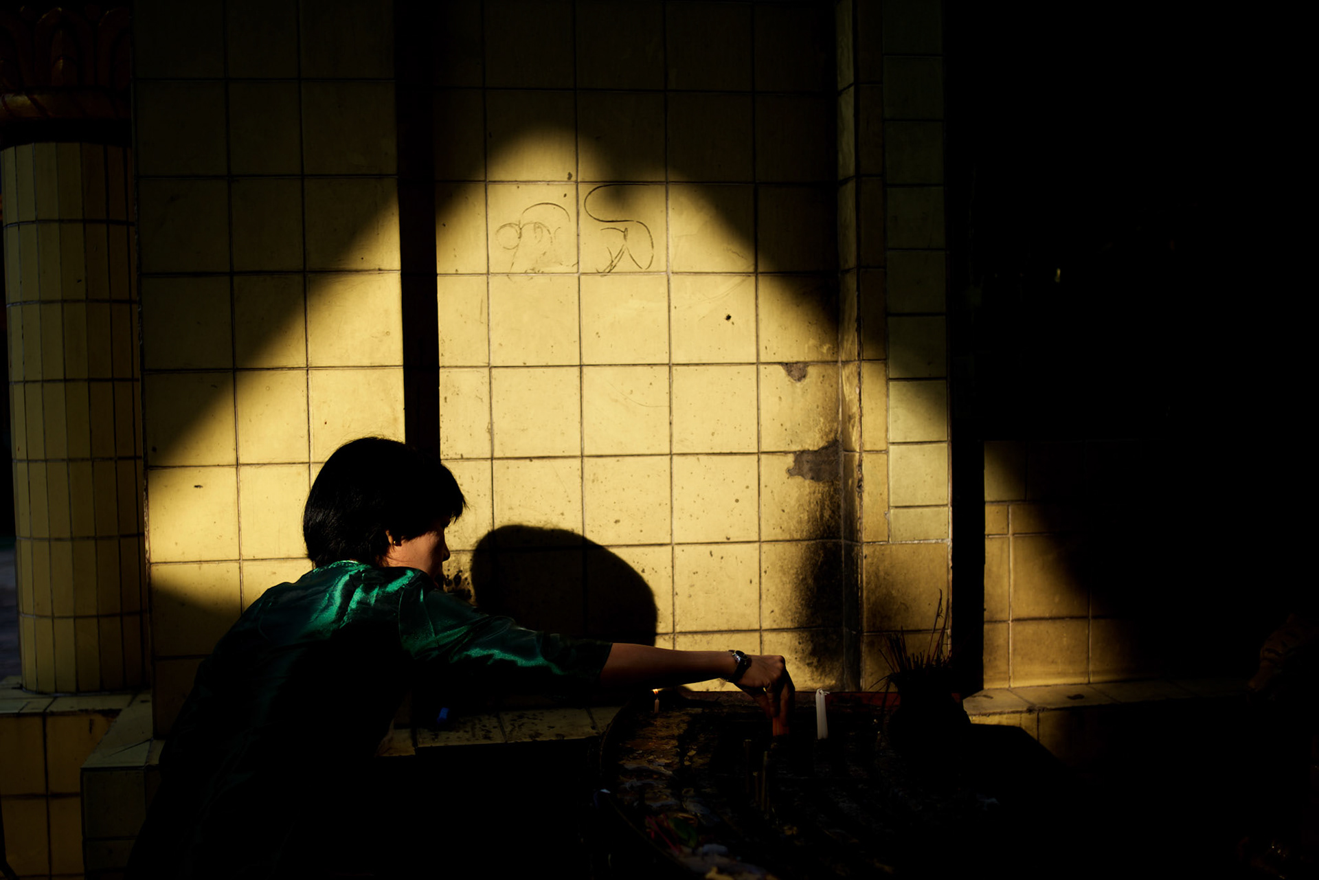 May 09, 2013 - Yangon, Myanmar: A woman lights candles at a shrine in Sule Pagoda, in central Yangon. CREDIT: Paulo Nunes dos Santos