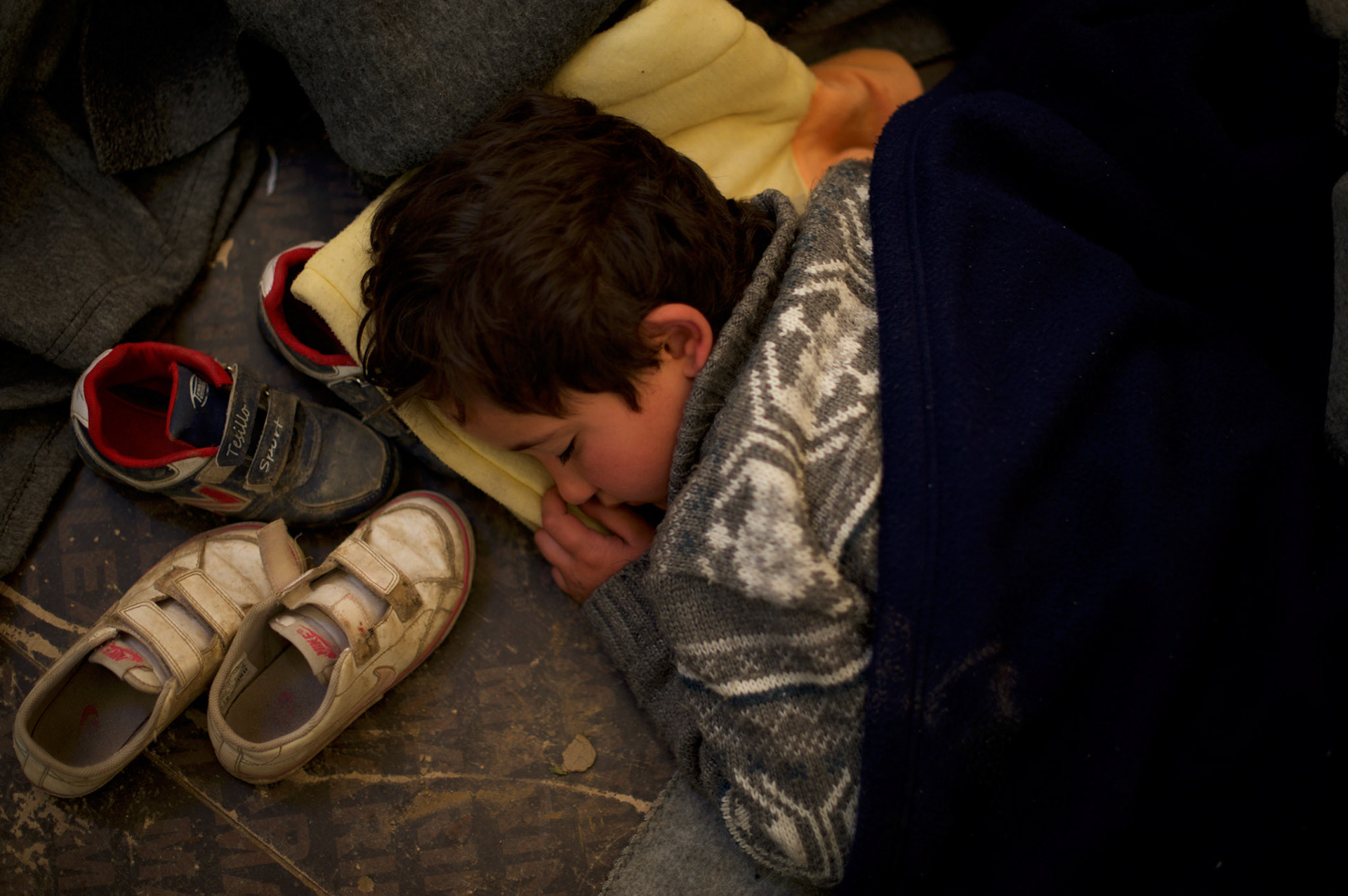A Syrian child sleeps on the floor of a emergency hospital tent run by volunteer organisations at the border between Greece and Macedonia in Idomeni, Greece. Around 13,000 migrants and refugees, mostly from the Middle East and African nations, are believe to be stranded here awaiting a chance to proceed their journey towards Germany and other northern European countries.