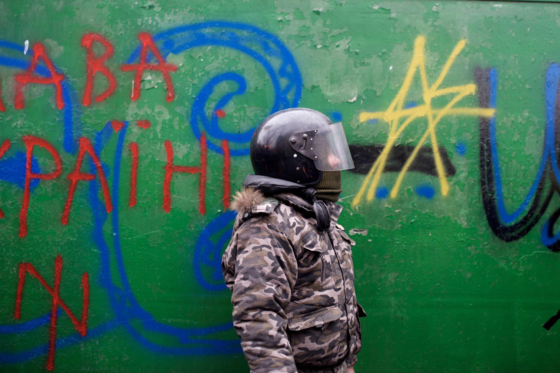 KIEV, UKRAINE - February 20, 2014: An anti-government protestors takes cover behind newly build barricades at the frontline where violent clashes were happening between protestors and riot police outside Independence Square in central Kiev. The riot police responded to the advance with gunfire that, according to the opposition, killed at least 70 and as many as 100 people. The drastic escalation of the three-month-old Ukraine crisis left the country reeling from the most lethal violence in decades. CREDIT: Paulo Nunes dos Santos
