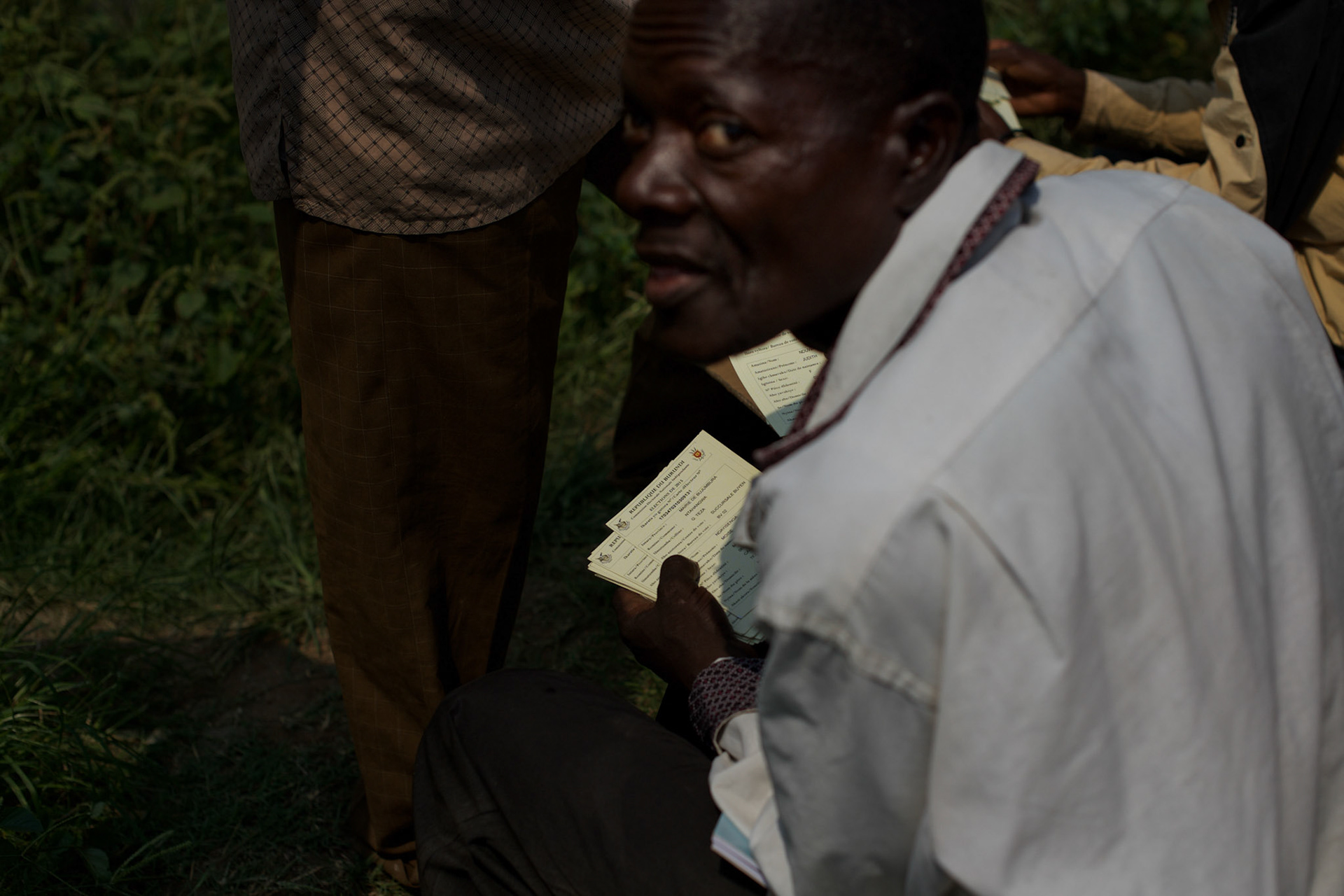 An unidentified man goes through the registration cards of voters at a polling station in Kinama neighbourhood, Bujumbura, June 29, 2015.