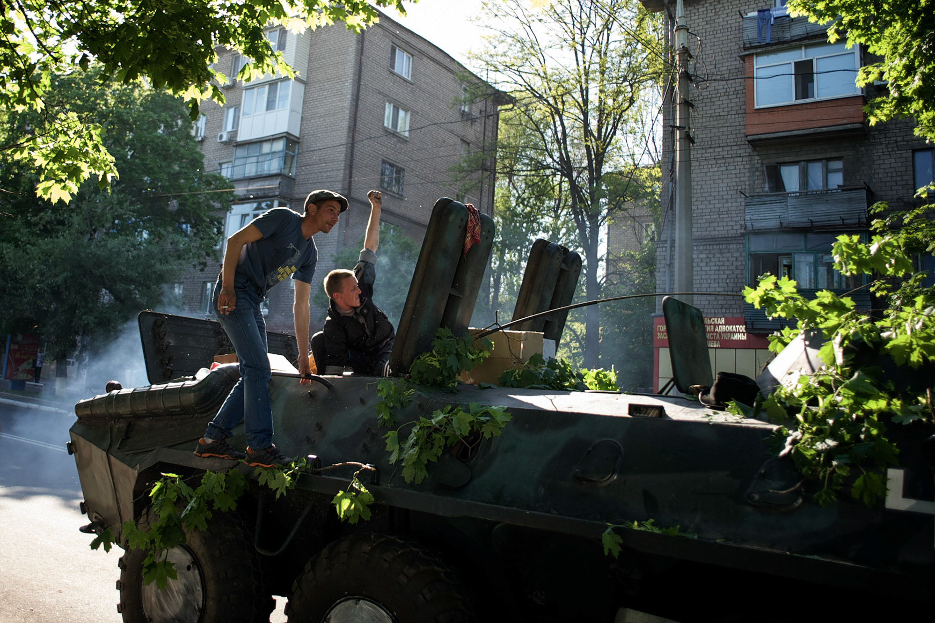 Separatists celebrate after they repaired the engine of an APC, abandoned by the Ukrainian army in Mariupol.