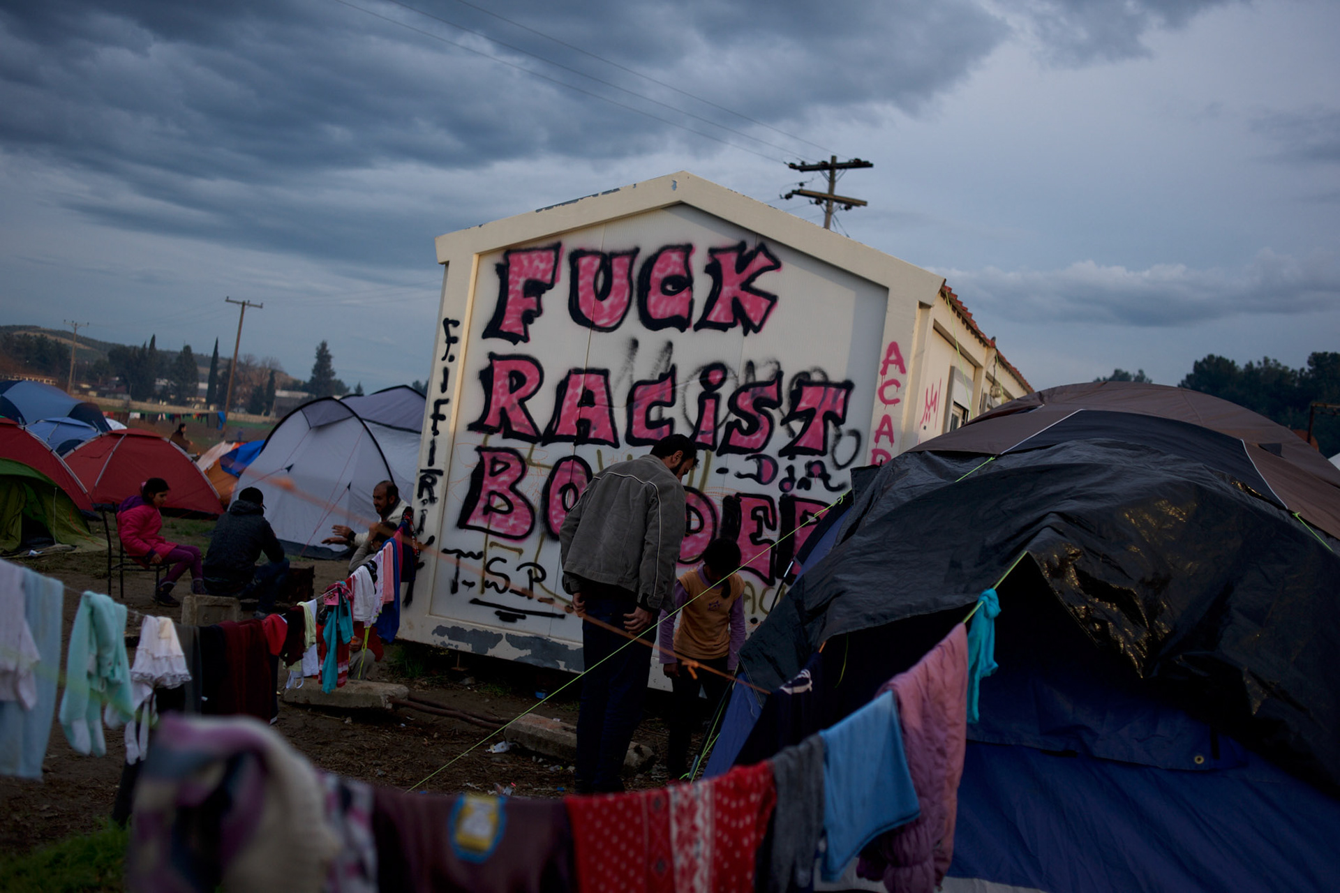 A graffiti stating "Fuck Racist Borders" is seen on a wall of a container among thousands of tents set up by migrants at the Greek-Macedonian border station of Idomeni, Greece. Around 13,000 migrants and refugees, mostly from the Middle East and African nations, are believe to be stranded here awaiting a chance to proceed their journey towards Germany and other northern European countries.