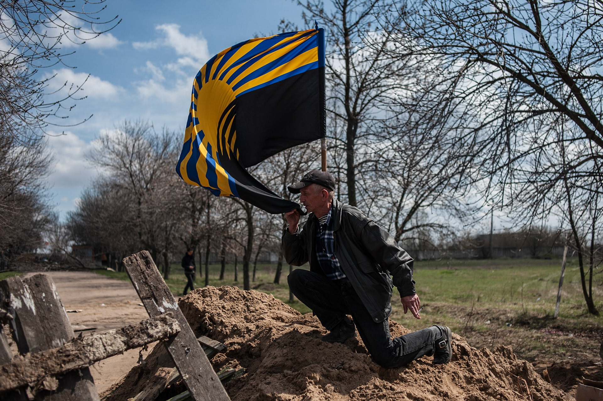 A man kisses the Donbass flag raised outside a military airbase near Kramatorsk.
