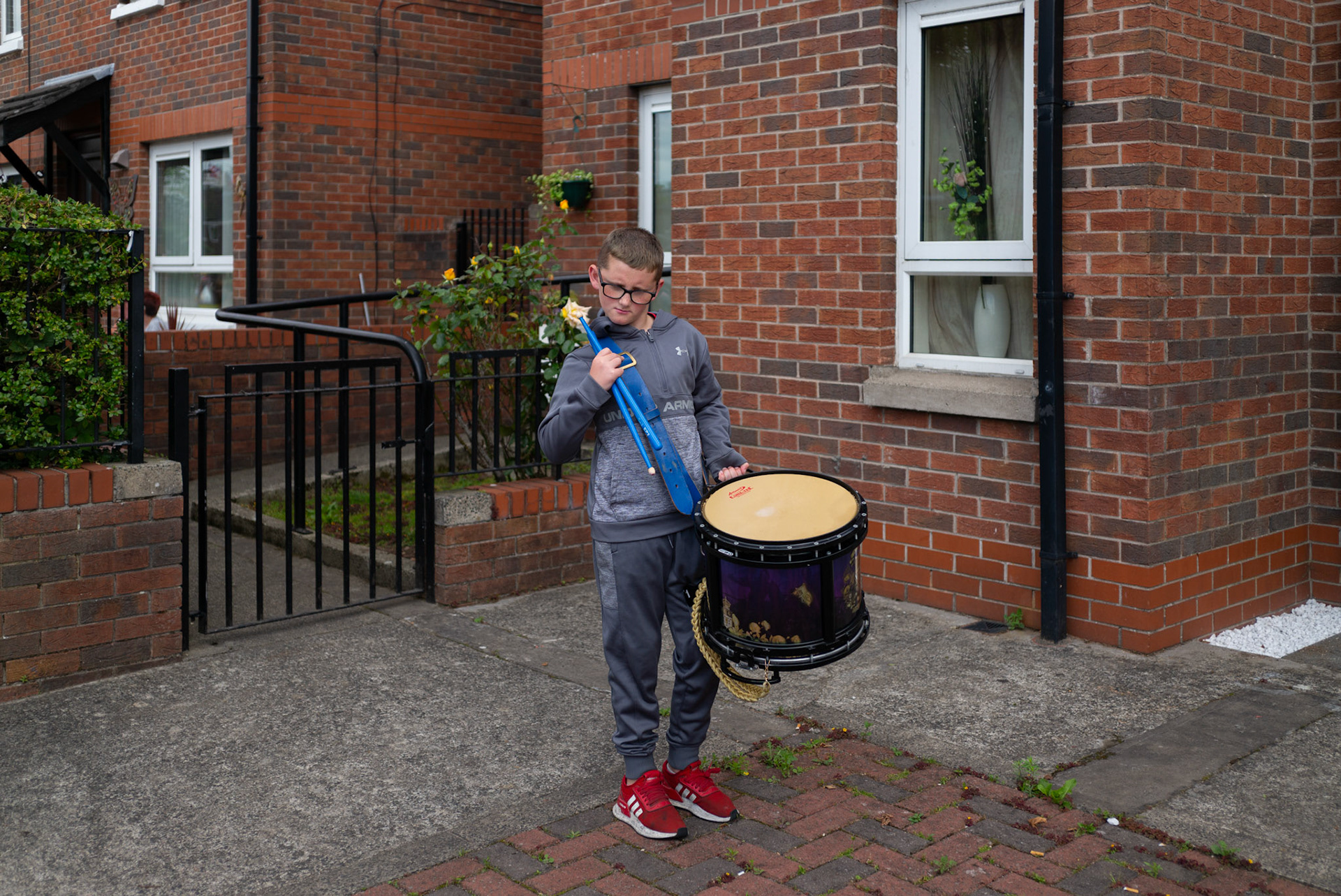 A junior member of the Young Conquerors South Belfast Flute Band practices outside his house in Donegall Pass, a predominantly working-class loyalist community in inner-city Belfast, Northern Ireland, on July 9, 2021.