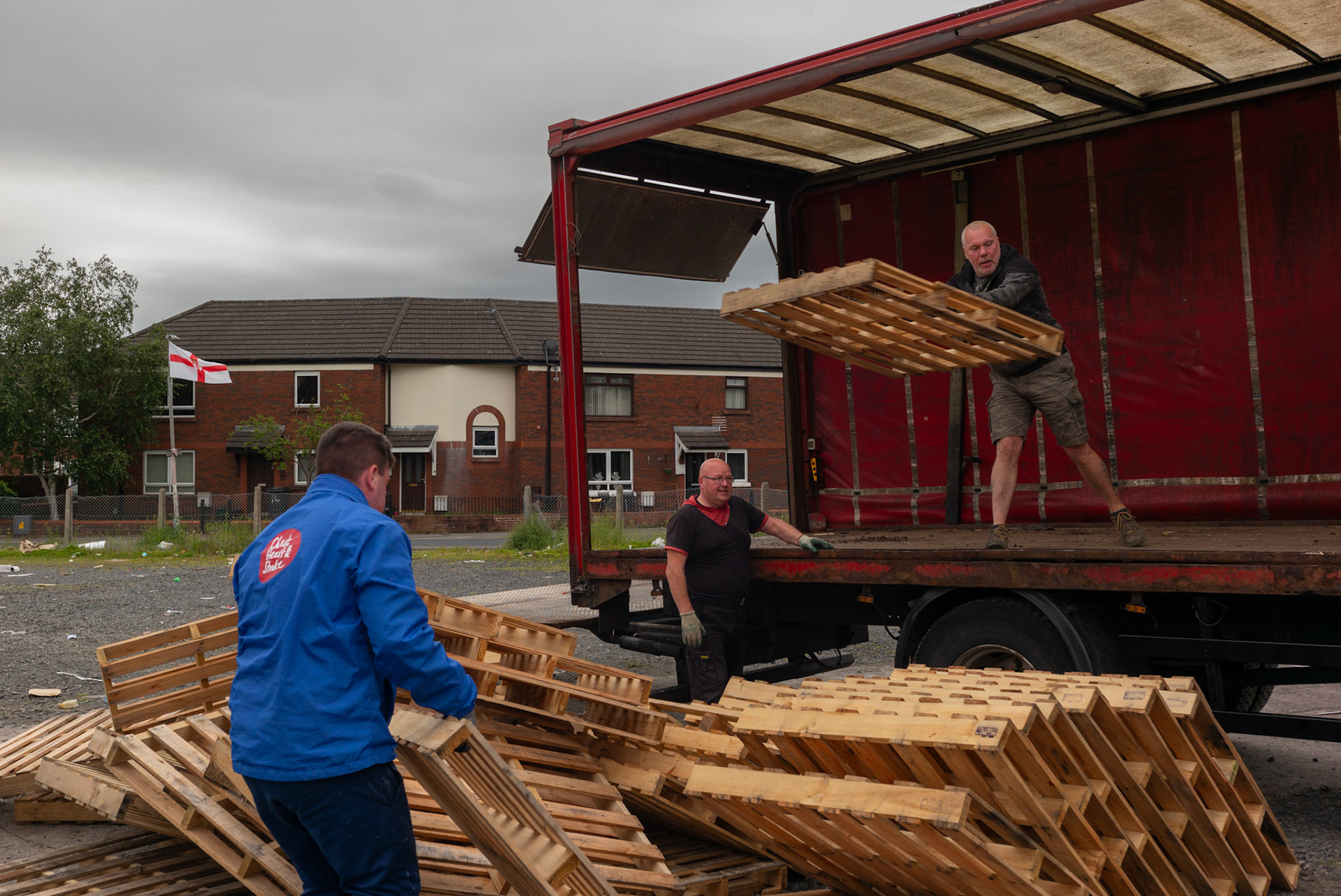 Youth from Donegall Pass, a predominantly working-class loyalist community in inner-city Belfast, help unload a truck delivering pallets for a traditional bonfire to be set alight during the Twelfth of July celebrations in Belfast, Northern Ireland, on June 26, 2021.