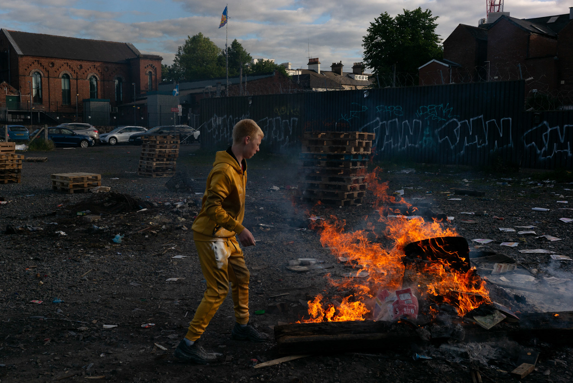 Local boys from Donegall Pass, a predominantly working-class loyalist community in inner-city Belfast, burn rubbish at a site used to build the large wooden pallet bonfire to be set alight during the Twelfth of July celebrations in Belfast, Northern Ireland, on June 25, 2021.