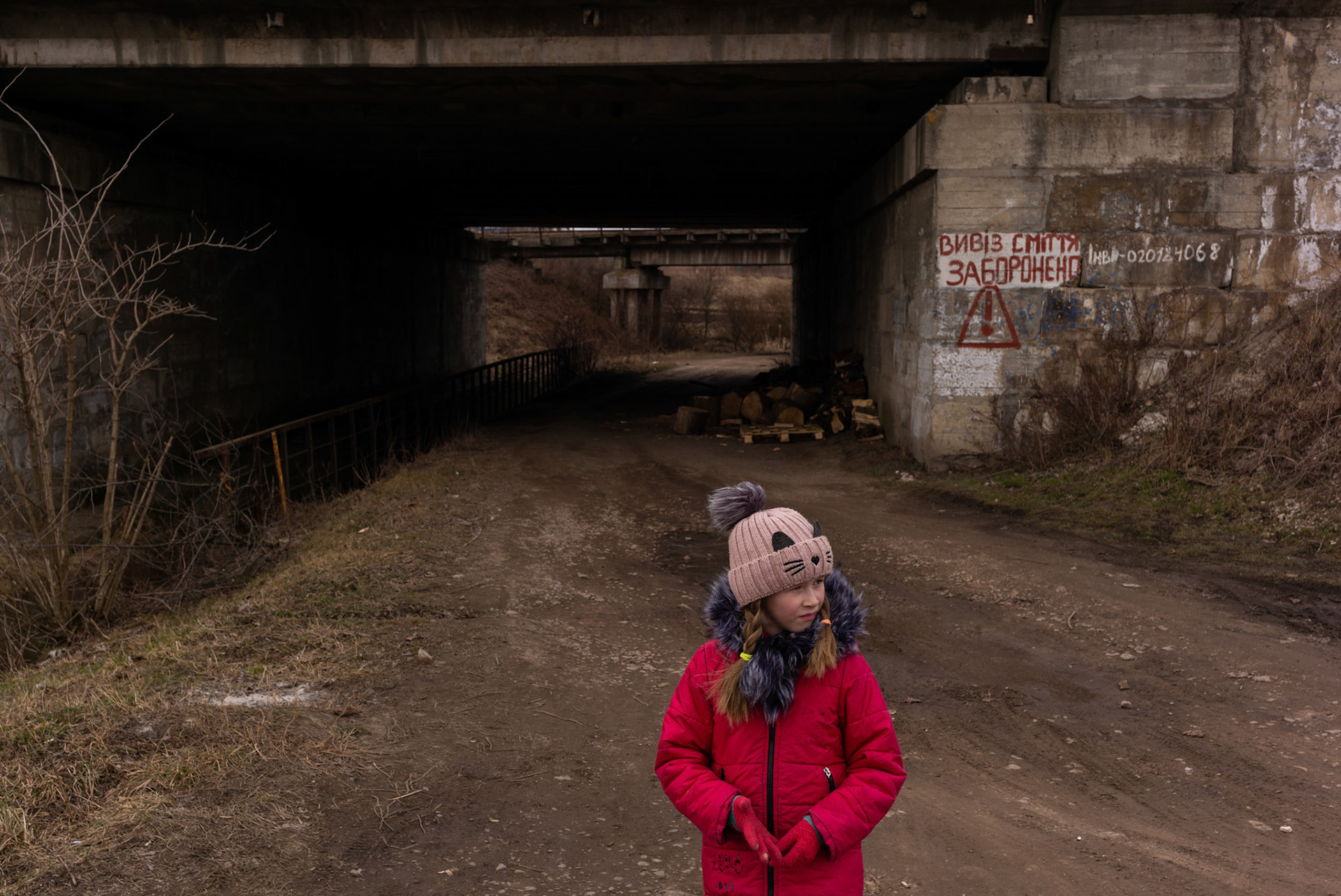 A child stands by a manned checkpoint in a road lead to a village in the outskirts of Lviv.