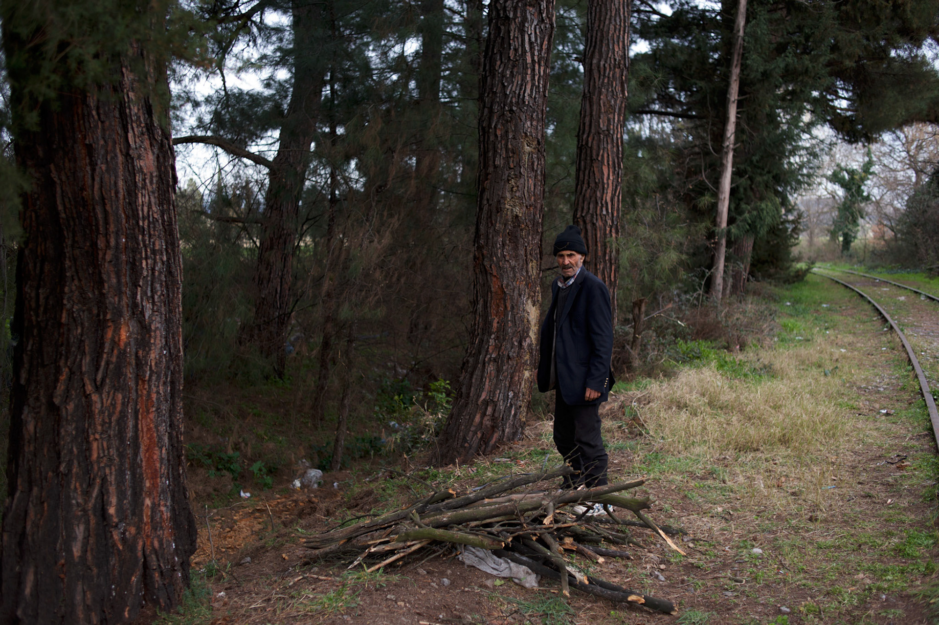 A Kurdish-Syrian man gathers wood for fire near the border between Greece and Macedonia in Idomeni, Greece. Around 13,000 migrants and refugees, mostly from the Middle East and African nations, are believe to be stranded here awaiting a chance to proceed their journey towards Germany and other northern European countries.