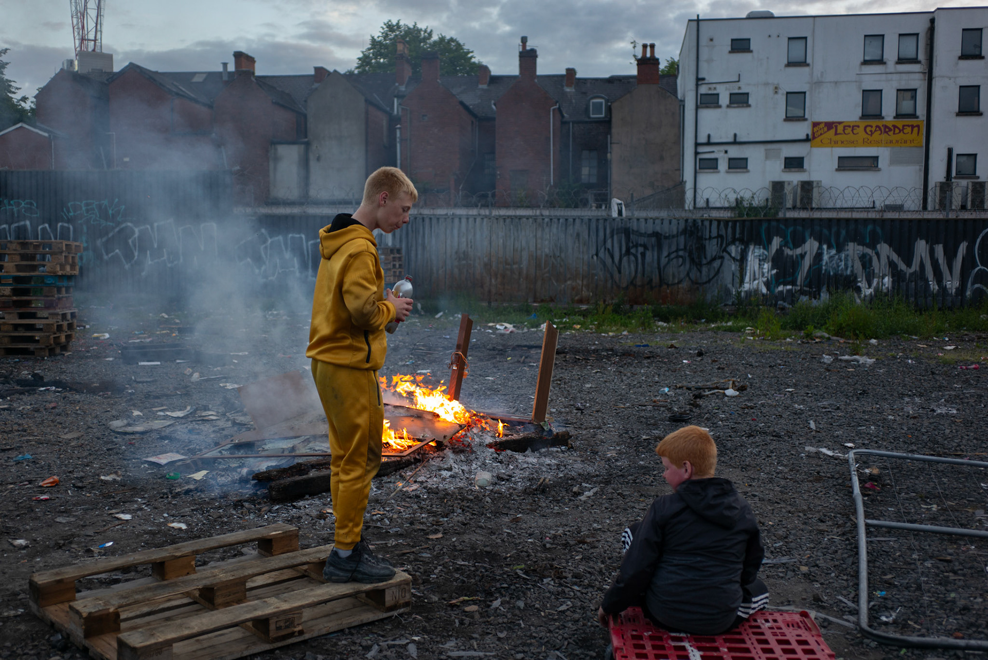 Local boys from Donegall Pass, a predominantly working-class loyalist community in inner-city Belfast, burn rubbish at a site used to build the large wooden pallet bonfire to be set alight during the Twelfth of July celebrations in Belfast, Northern Ireland, on June 25, 2021.