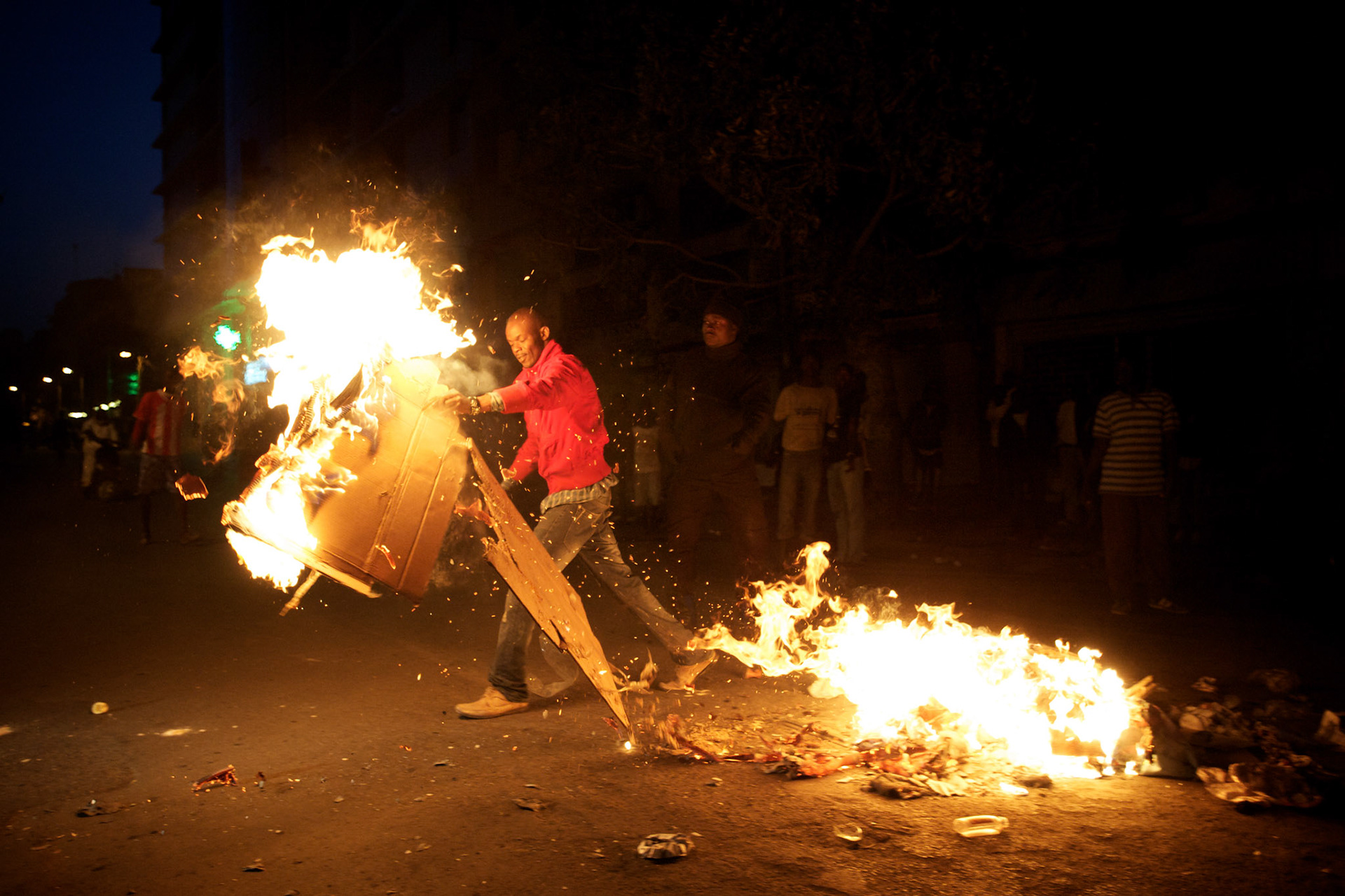 February 23, 2012 - Dakar, Senegal: A opposition supporter sets alight a road block during a protest against the candidature of the current president Abdoulaye Wade for a anti-constitutional third candidature to as head of state. Tensions between police and opposition supporters have been high in the capital Dakar and other cities around the country, where some clashes have happen ahead of the presidential elections on the 26th of February. At least fourteen people have died in the past month. (Paulo Nunes dos Santos/Polaris)