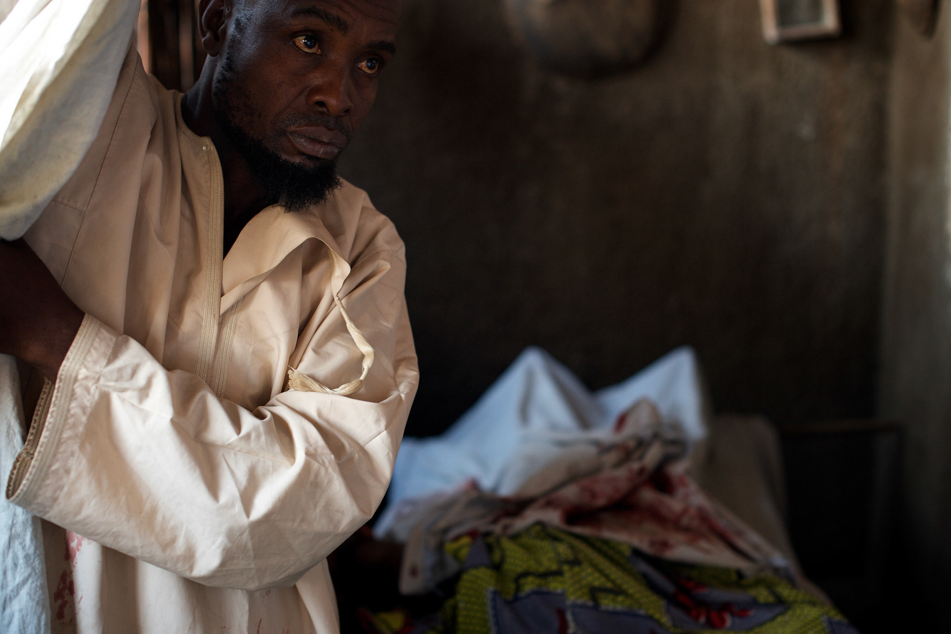 A local man show's the body of Abdul Masumbuko, a young man allegedly killed by a grenade he was handling in Jade neighbourhood in Bujumbura, June 28, 2005.
