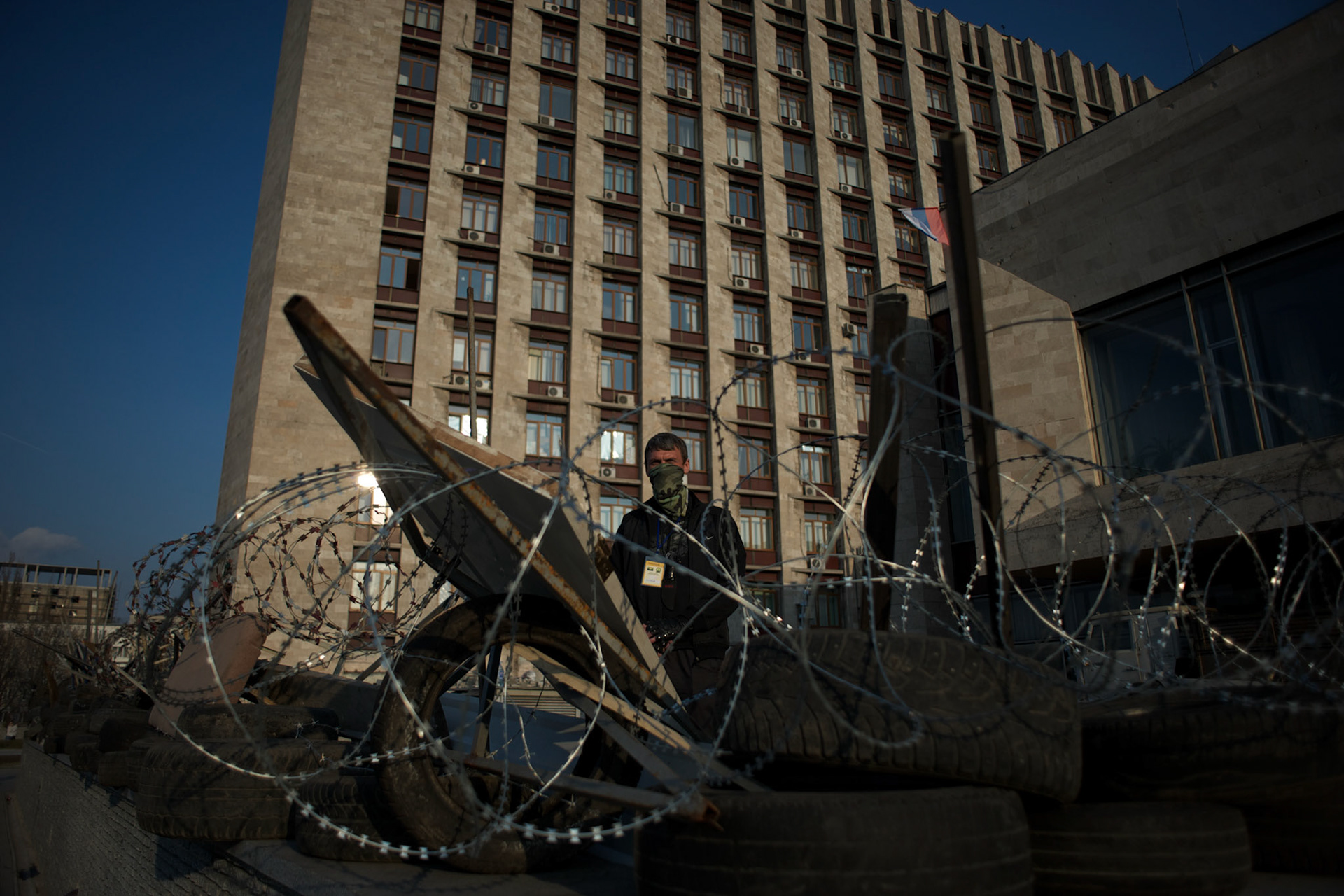 A separatist mans the barricades surrounding a government building in Donetsk.