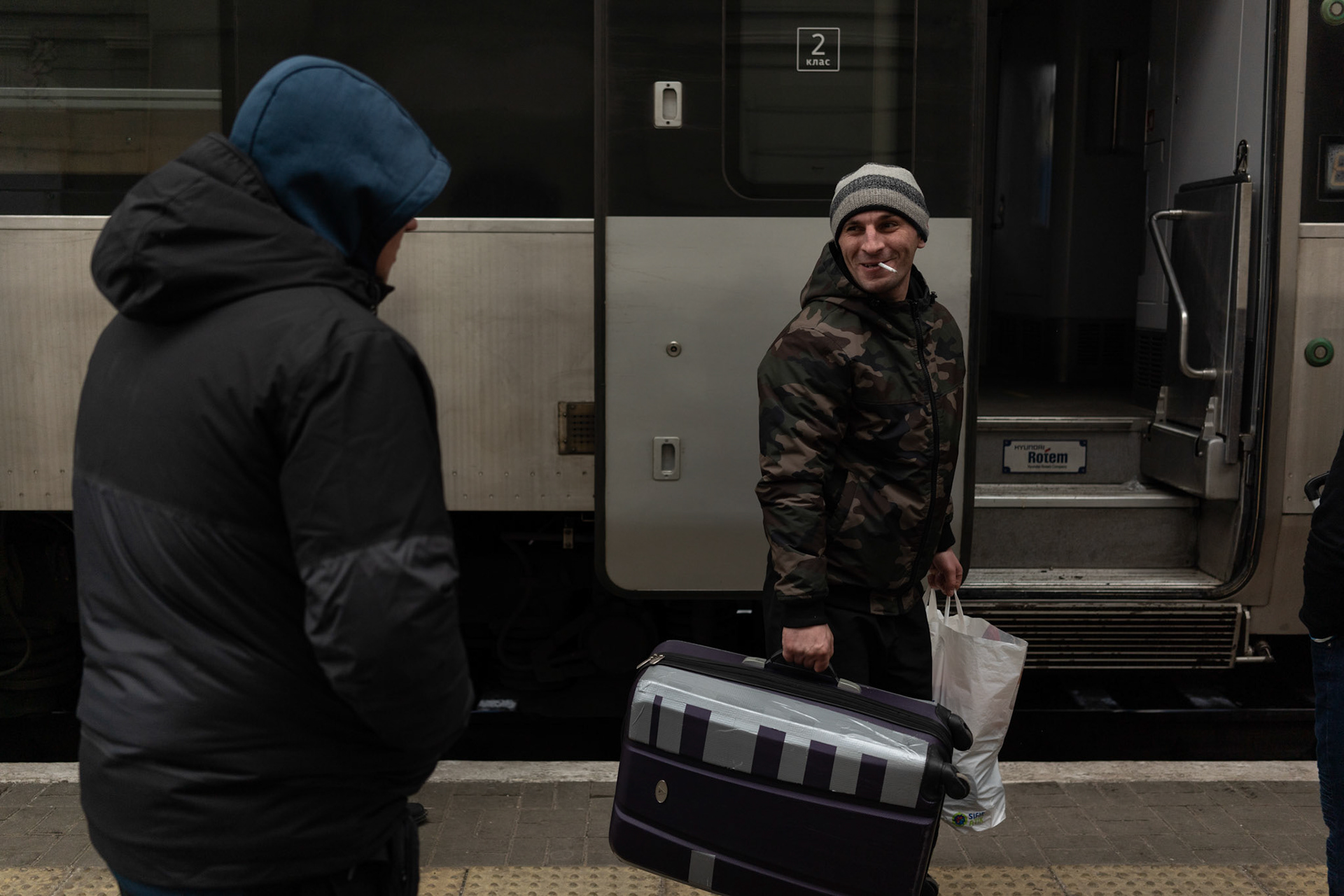 An Ukrainian man says goodbye to a relative as he boards a train leaving Lviv towards Kyiv, where he will be fighting against the Russian troops.