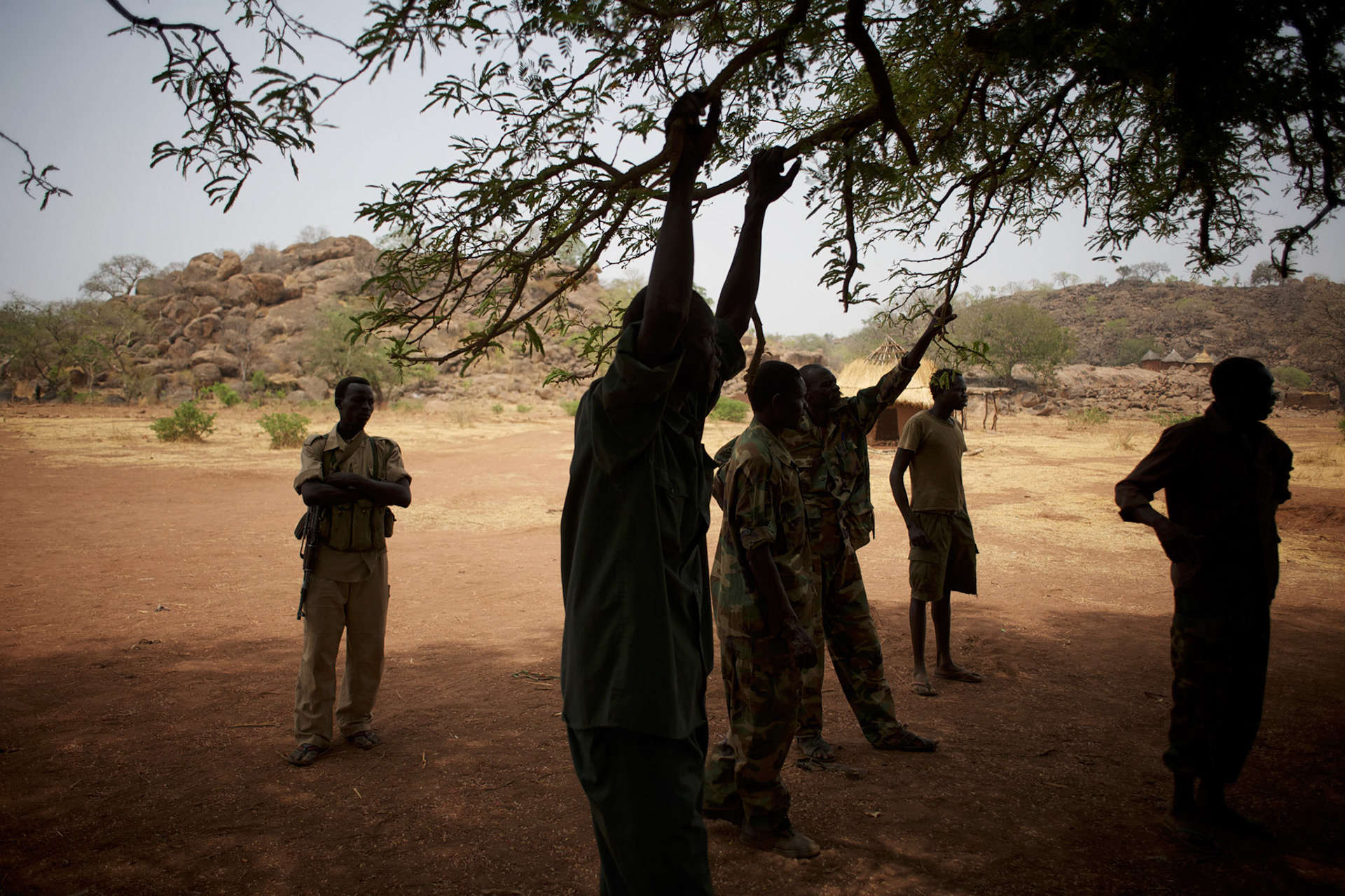 A group of Sudan People's Liberation Movement (SPLA-N) rebel fighters relax outside Jebel Kwo military base near Tess village in the rebel-held territory of the Nuba Mountains in South Kordofan.