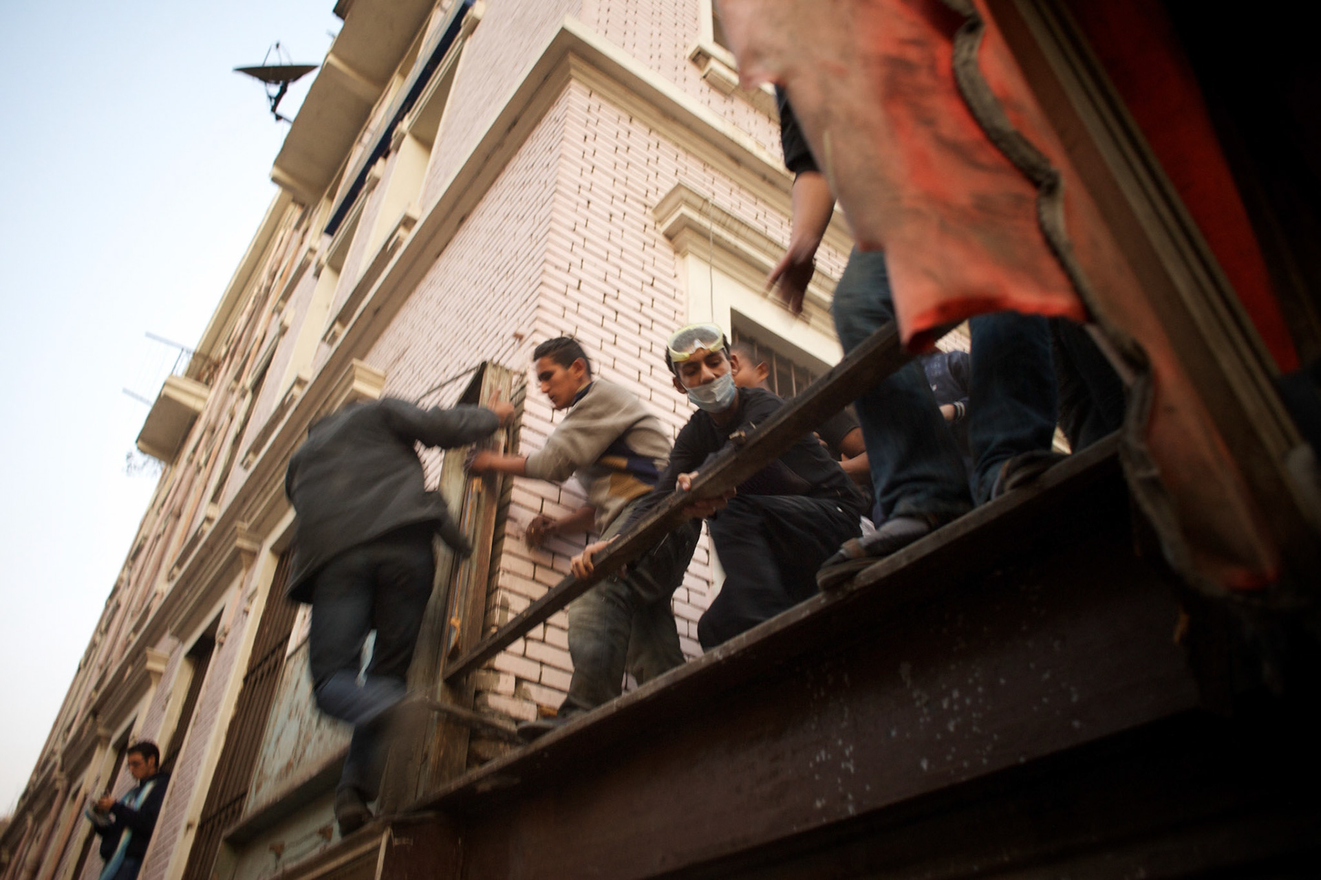 Egyptian men run for cover from an attack with rubber bullets and tear gas by the security forces in central Cairo.