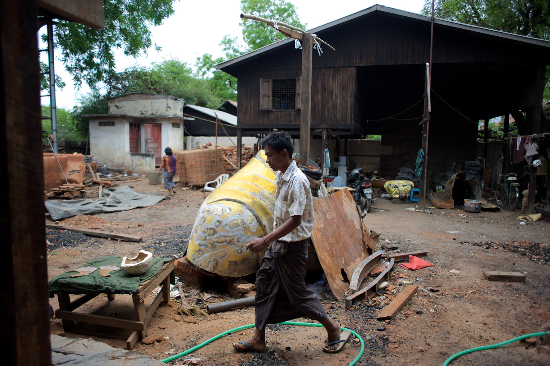May 14, 2013 - Mandalay, Myanmar: A local worker walks by in the yard of a traditional workshop in Mandalay. CREDIT: Paulo Nunes dos Santos