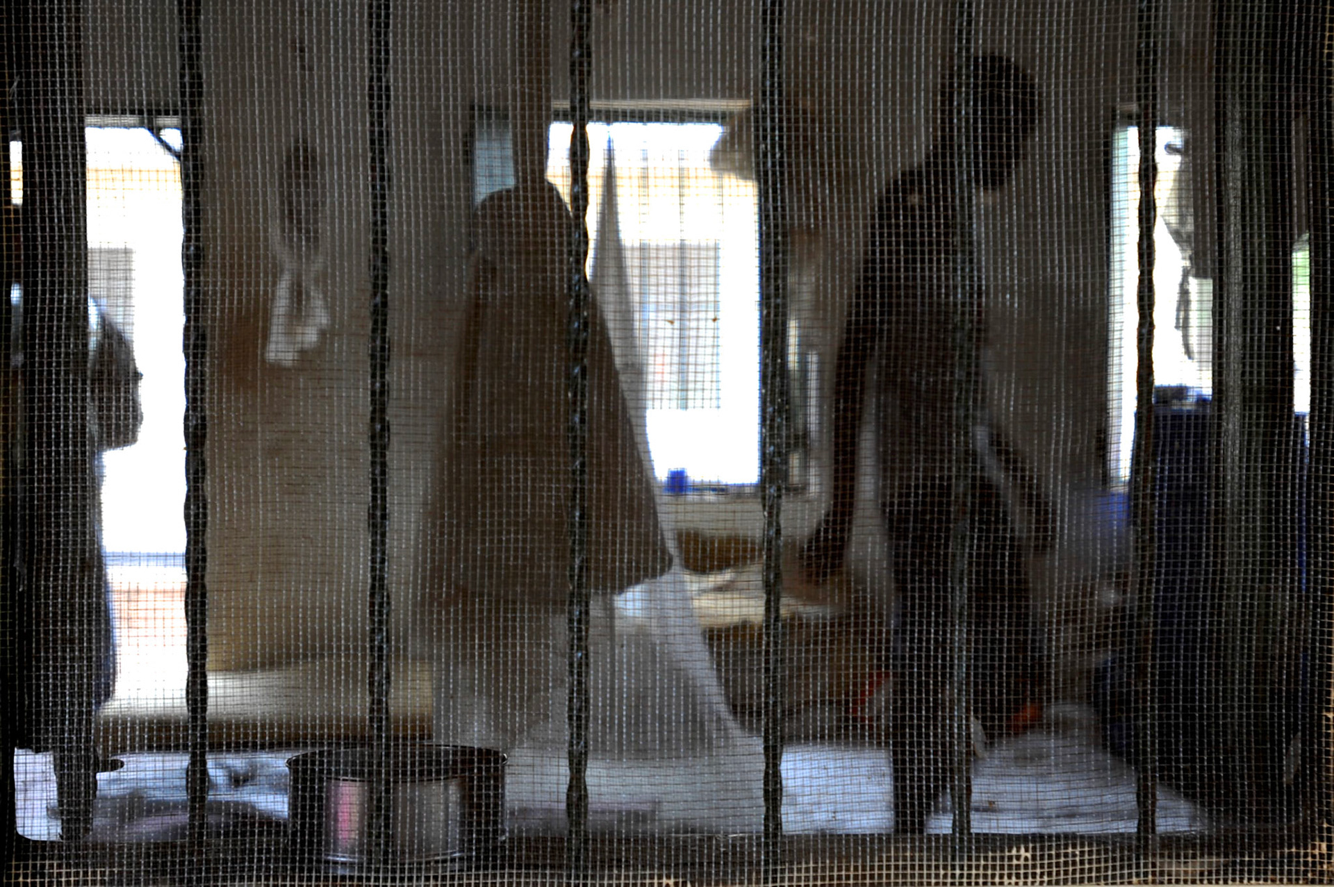 A child inmate is seen walking inside a communal cell at Juba Central Prison. The prison accommodates dozens of inmates with ages between fourteen and eighteen years old, many charged with murder and theft.